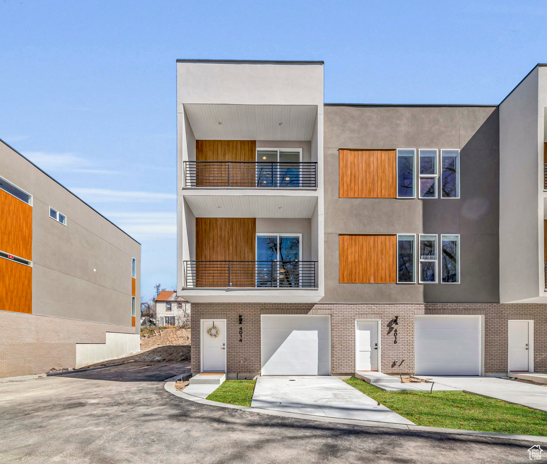 View of front of house with a garage and a balcony