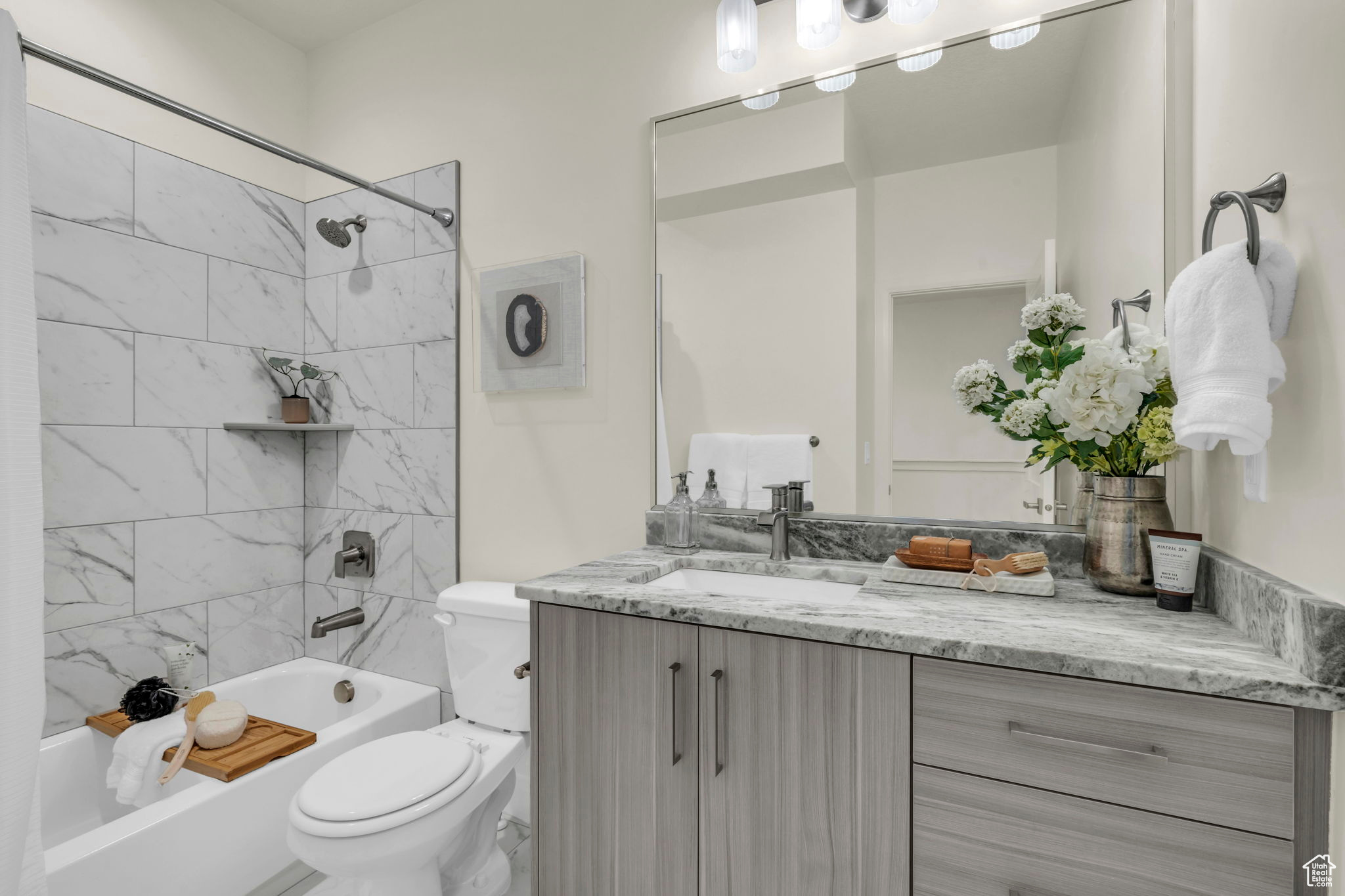 Full bathroom featuring tiled shower / bath, large vanity, and toilet