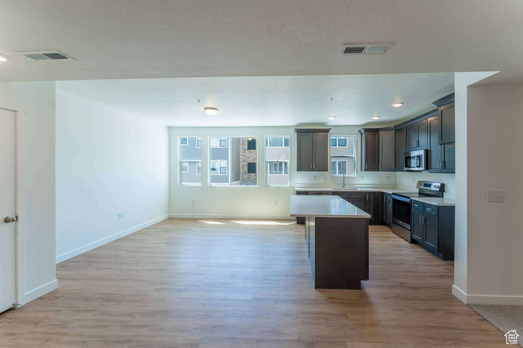 Kitchen with a center island, light hardwood / wood-style flooring, and stainless steel appliances