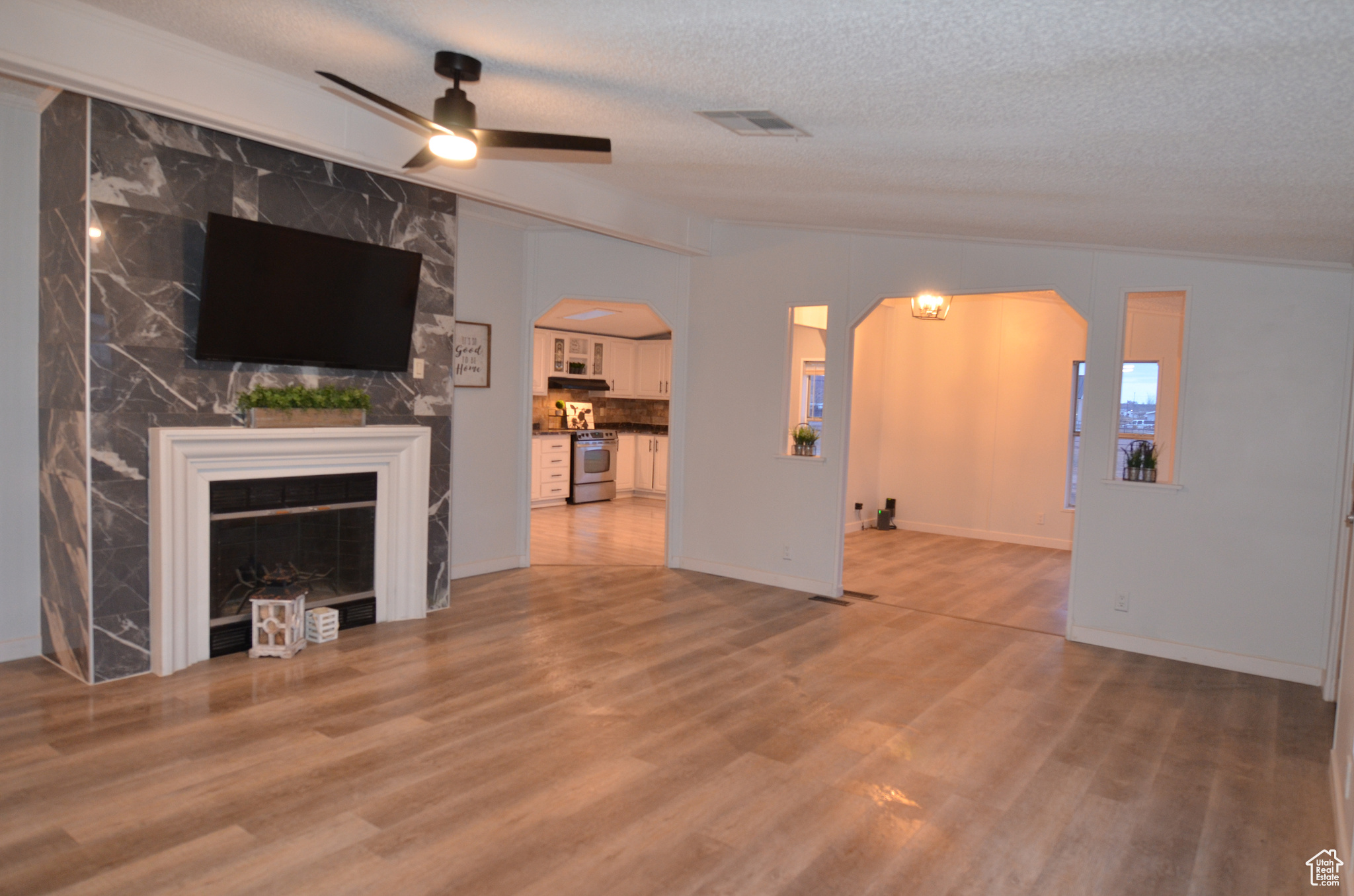 Living room featuring a textured ceiling, LVP flooring, and ceiling fan