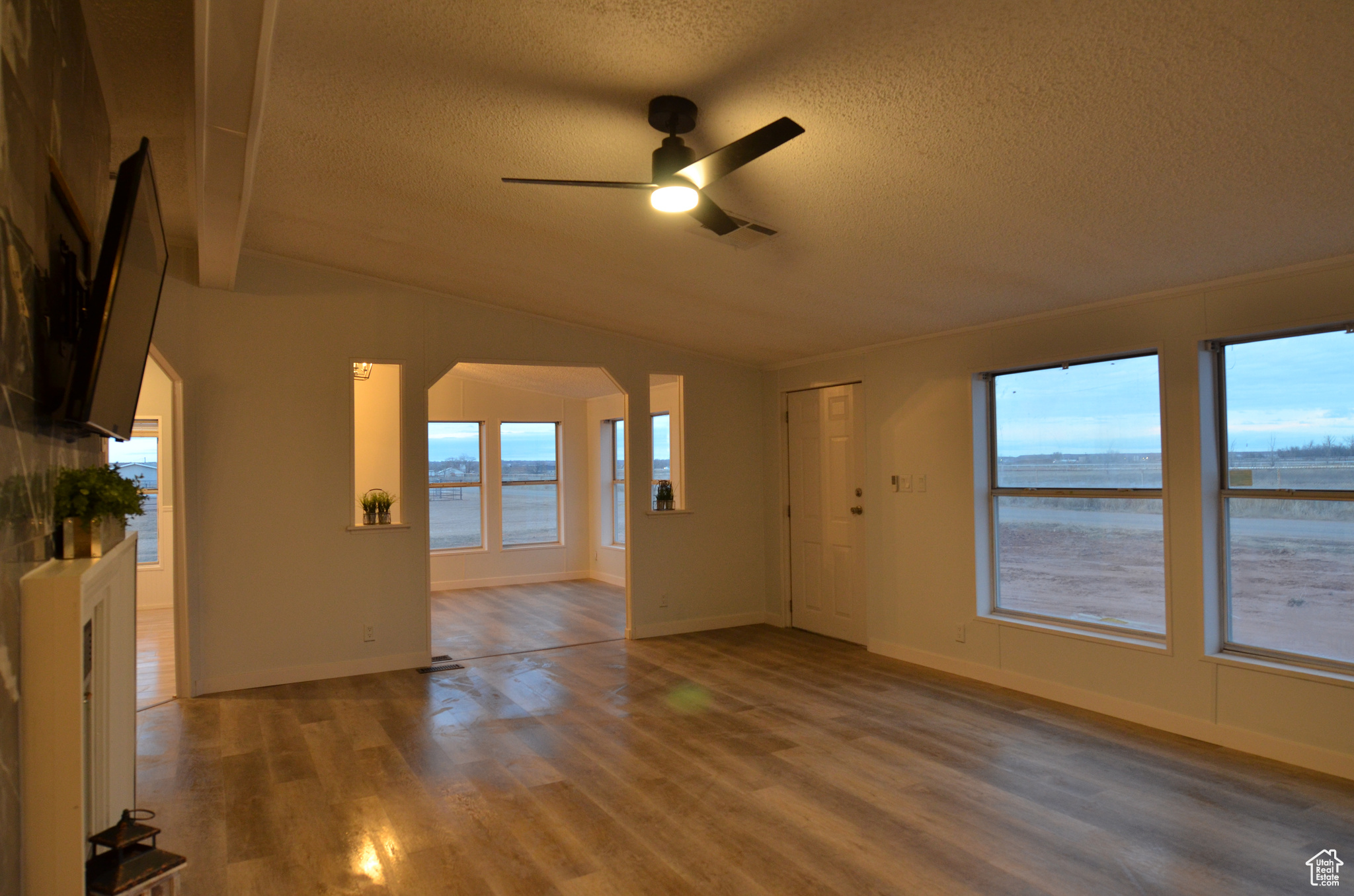 Living room with vaulted ceiling, LVP flooring, and ceiling fan