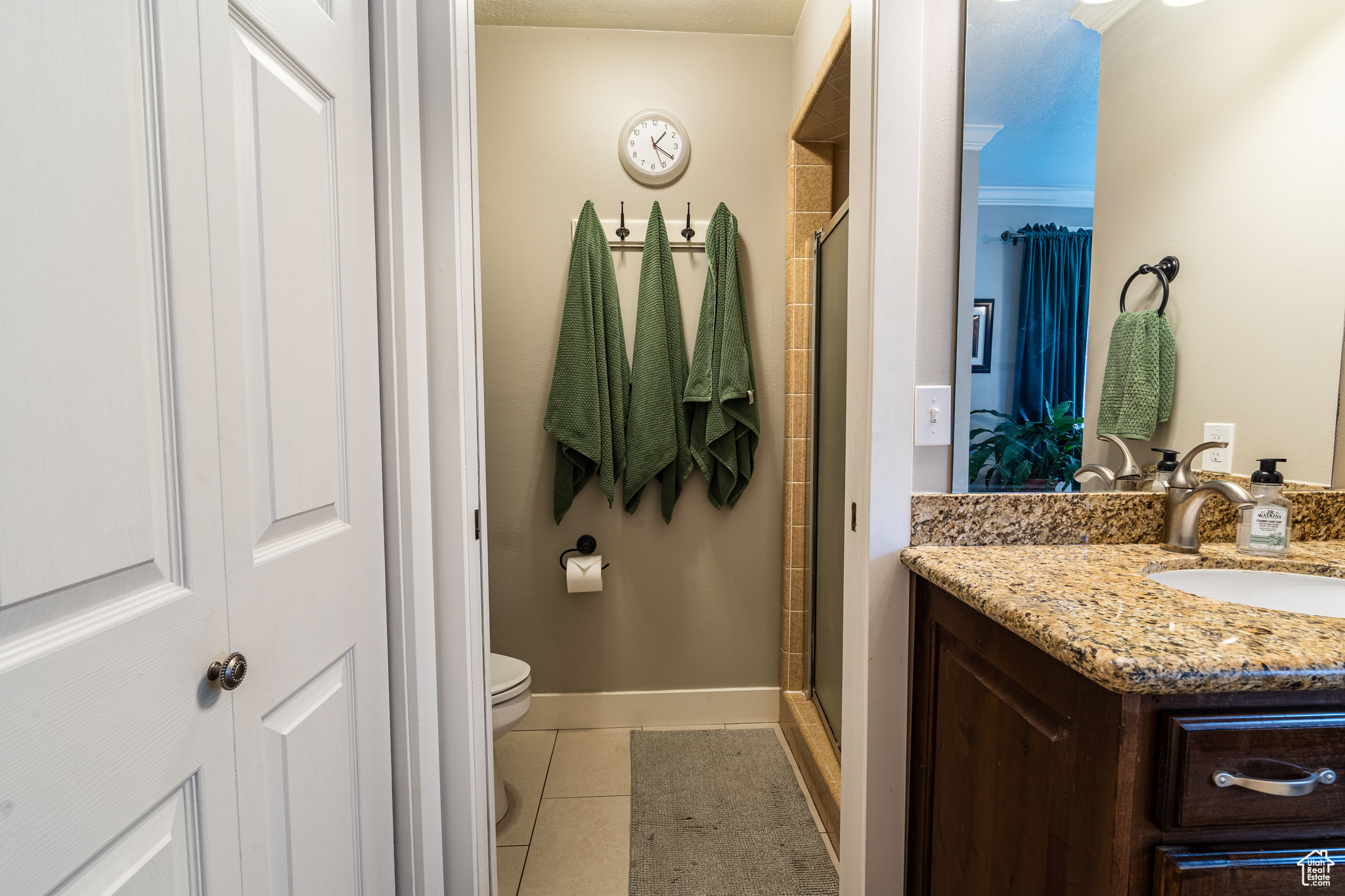 Master suite with vanity, a shower with door, toilet, tile floors, and crown molding
