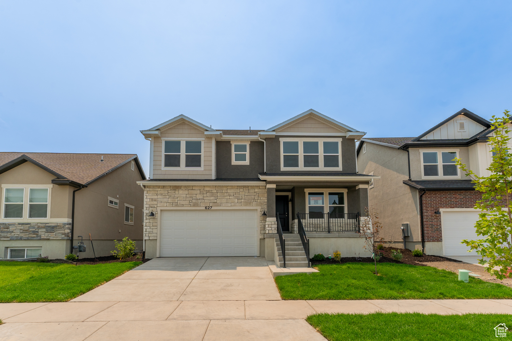 View of front of property with a garage and a front lawn