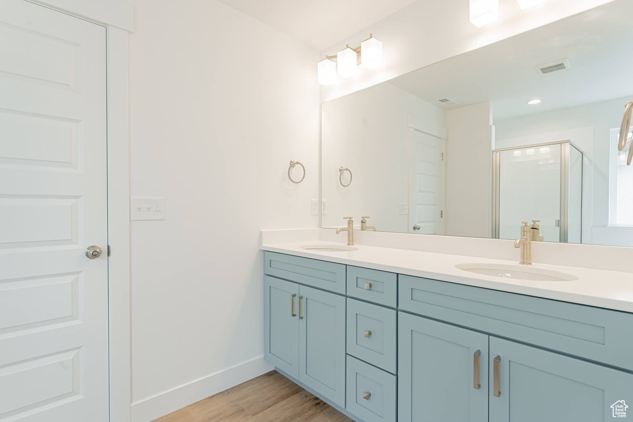 Bathroom featuring hardwood / wood-style flooring and dual bowl vanity