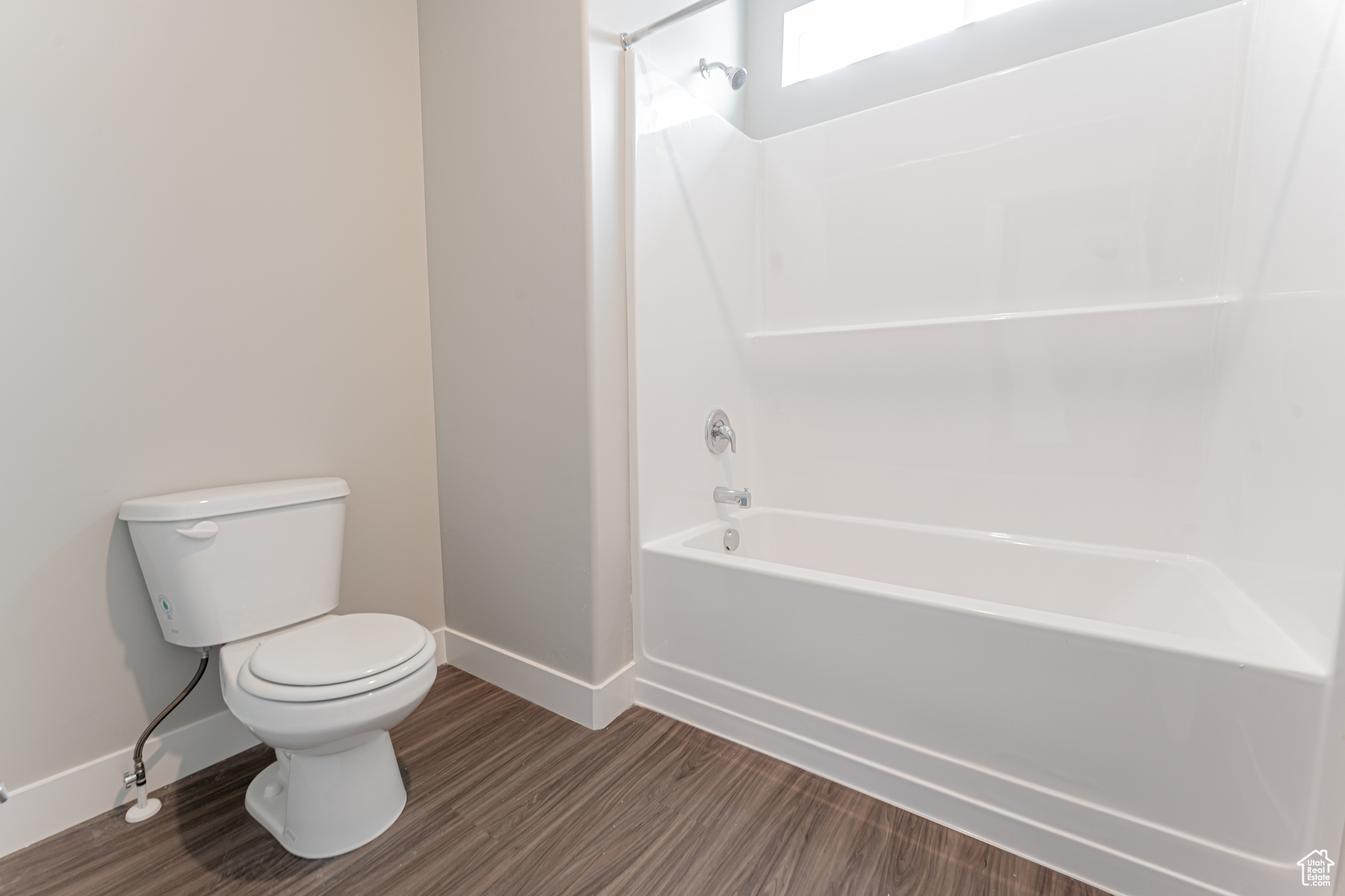 Bathroom featuring toilet, hardwood / wood-style floors, and tub / shower combination