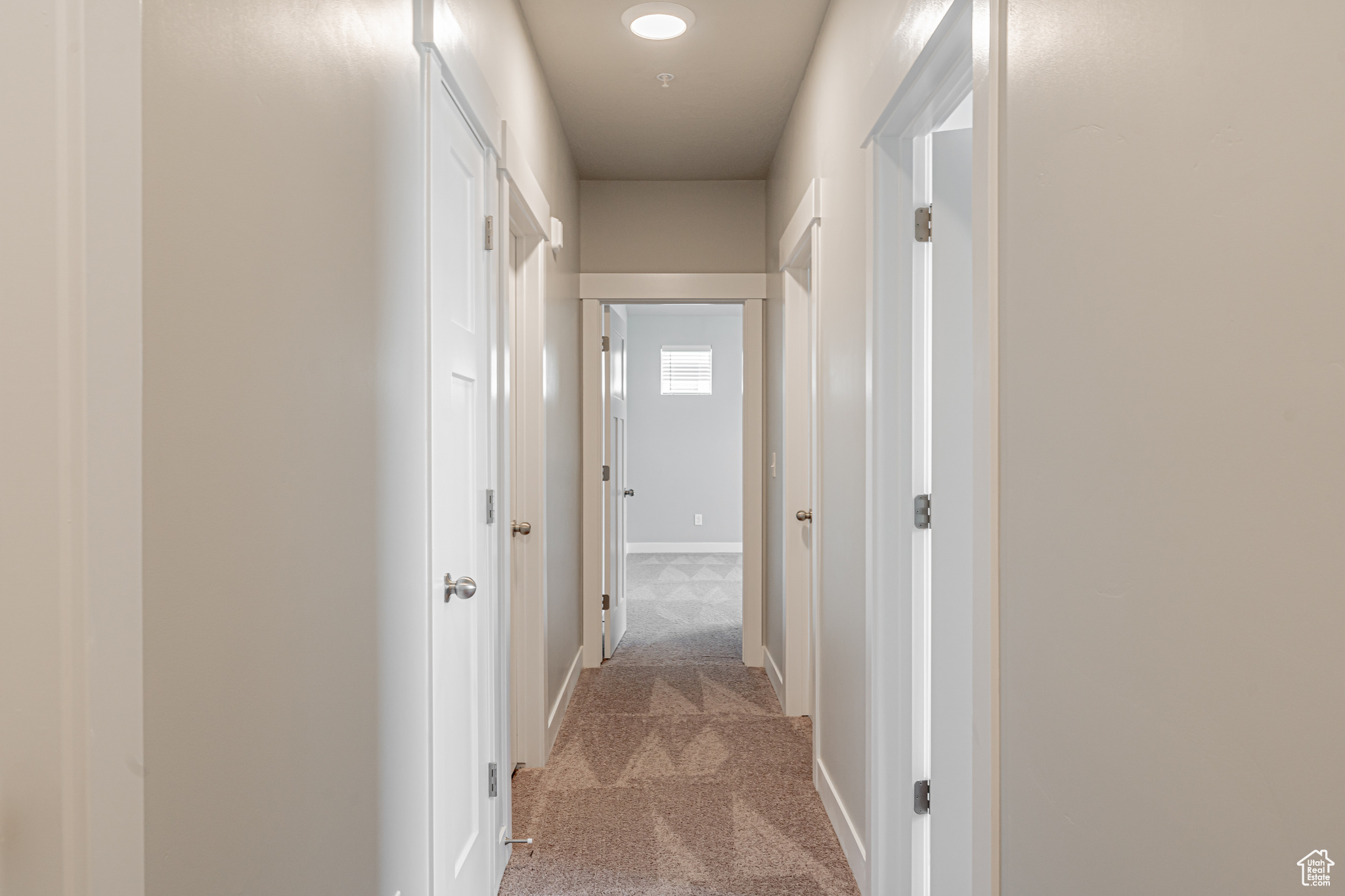 Corridor featuring light carpet