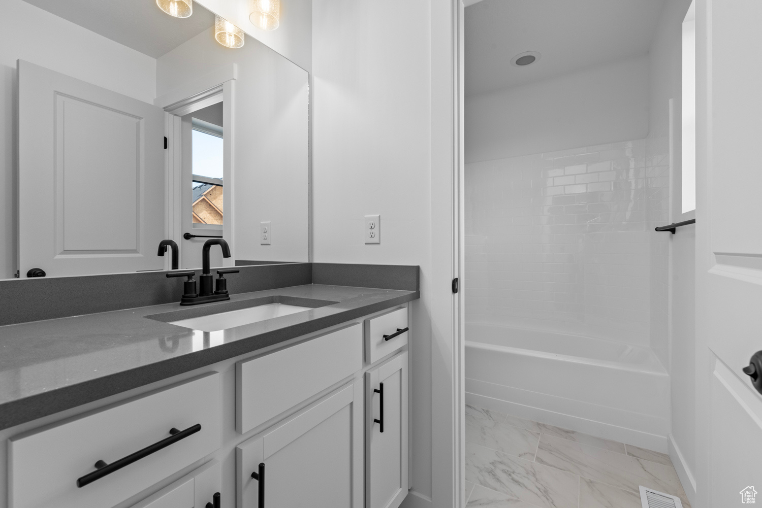 Bathroom with tile patterned flooring, vanity, and tub / shower combination