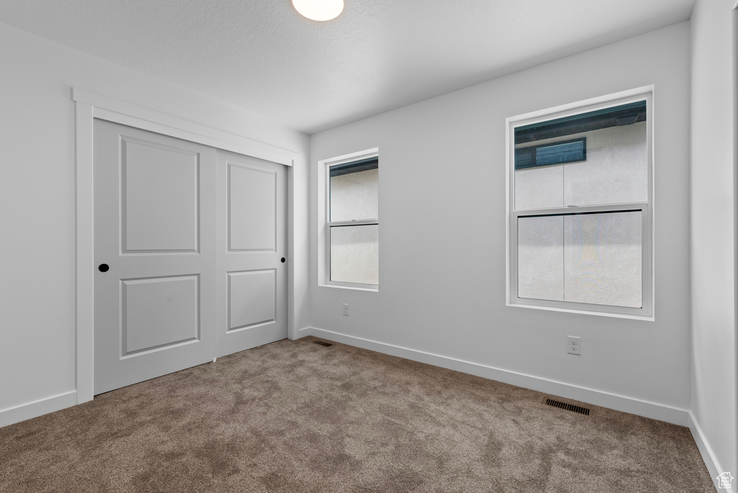 Unfurnished bedroom with a closet and carpet