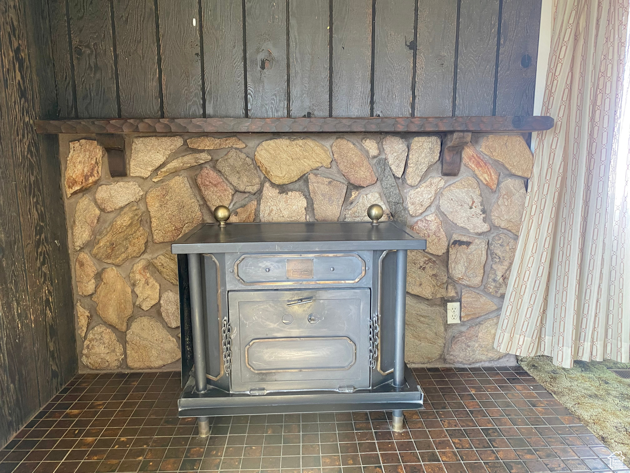 Exterior details featuring a wood stove and dark tile floors