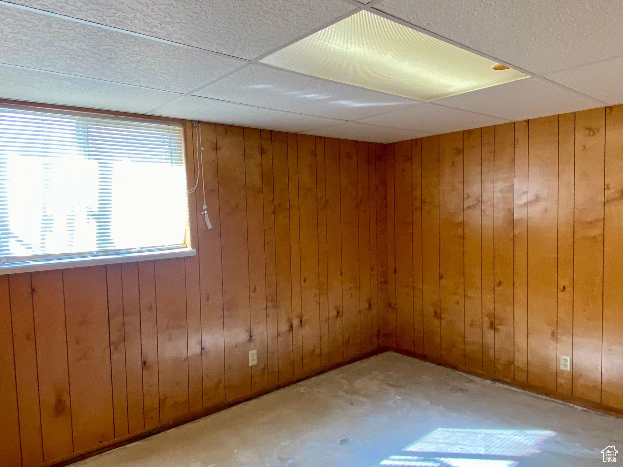 Spare room with wooden walls and a drop ceiling