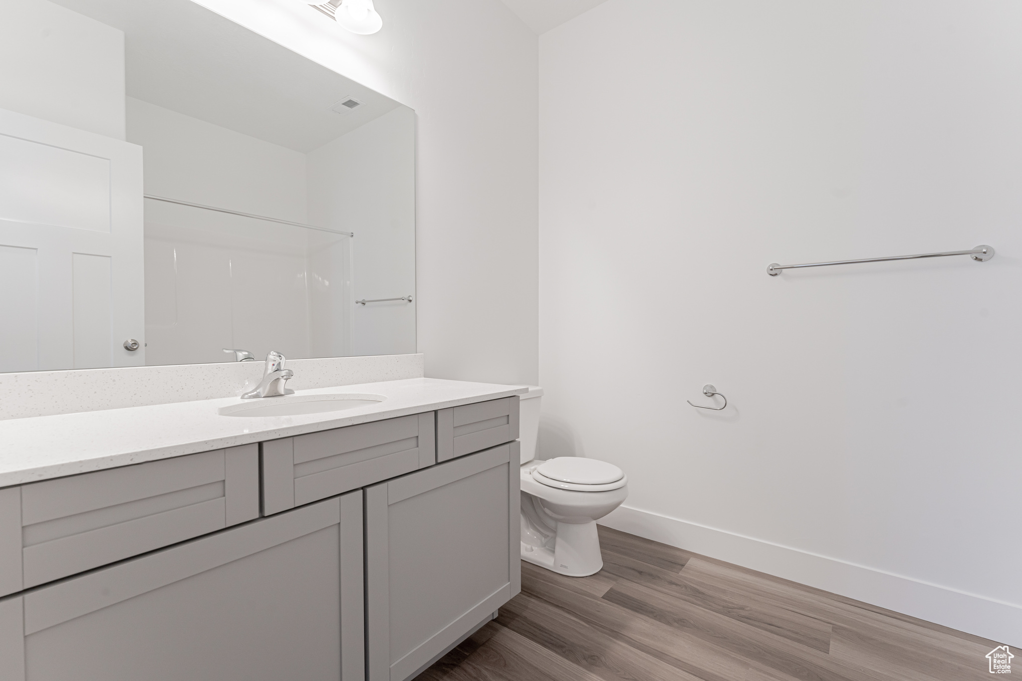 Bathroom featuring toilet, a shower, vanity, and wood-type flooring