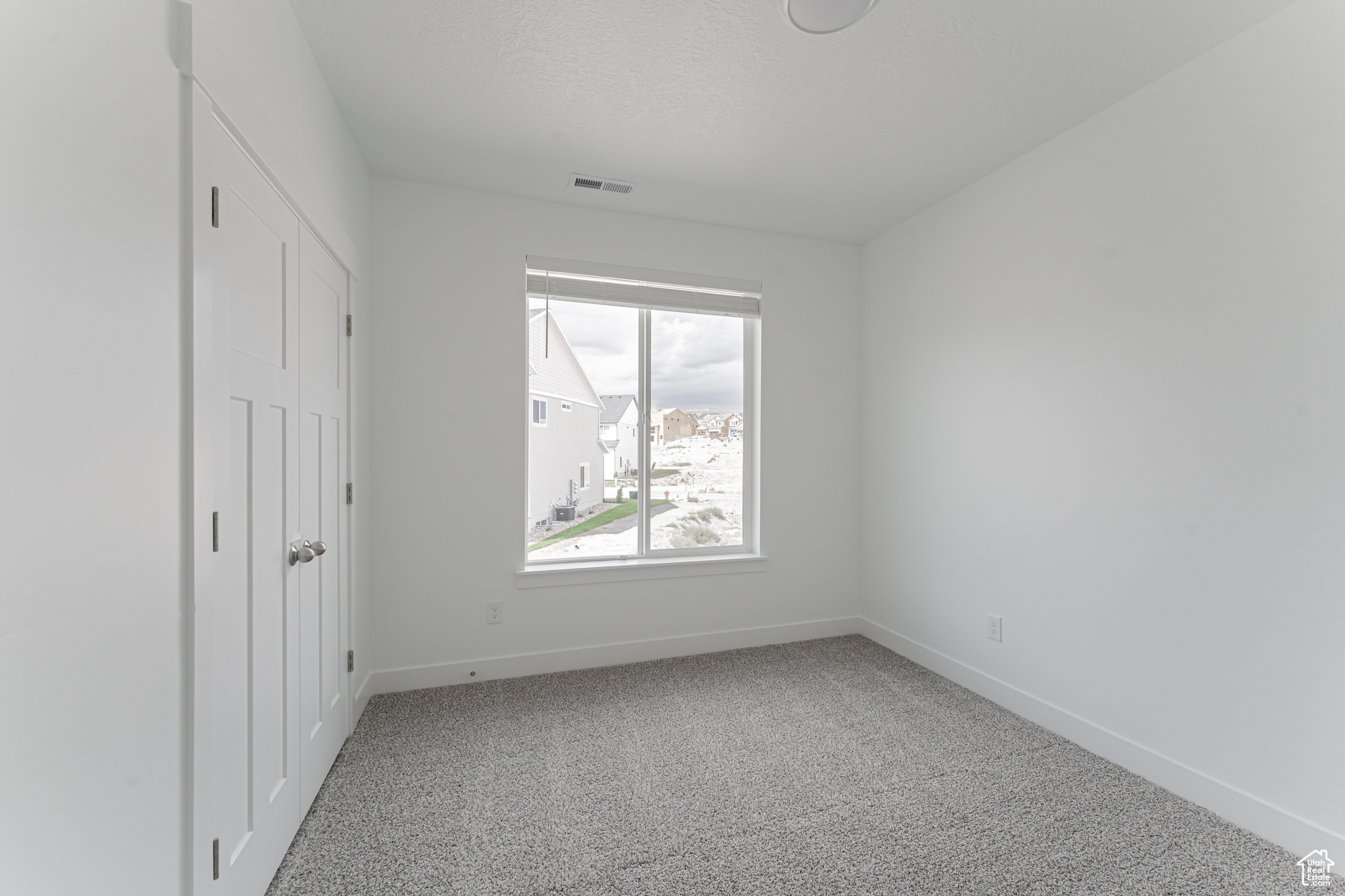 Unfurnished bedroom with light colored carpet