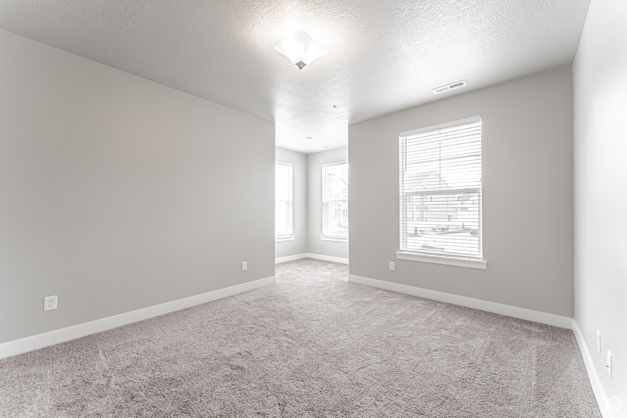 Spare room with a textured ceiling and carpet floors