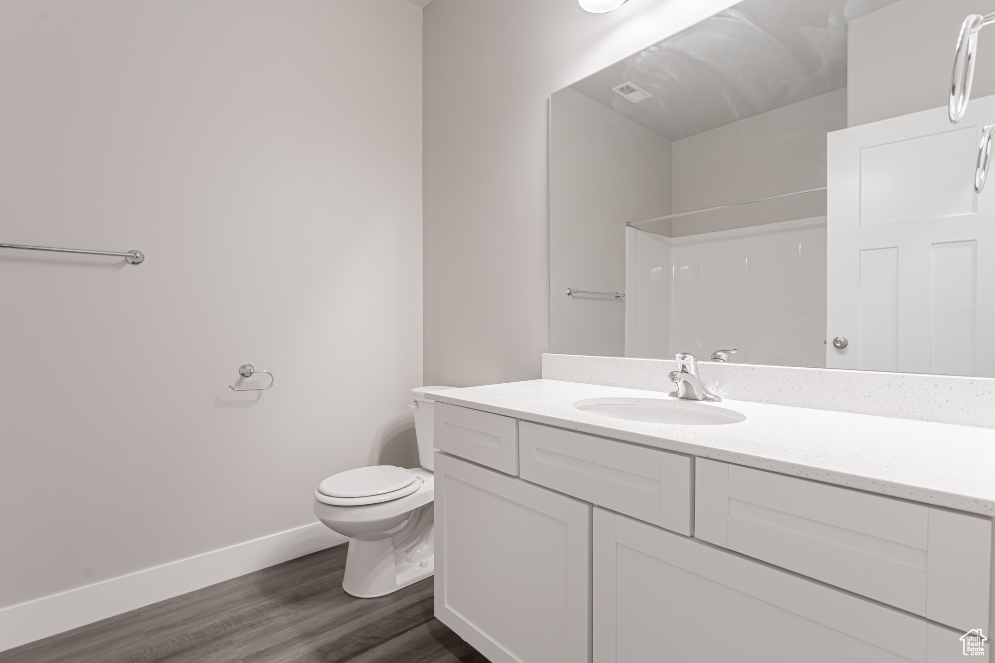 Bathroom featuring wood-type flooring, toilet, and vanity