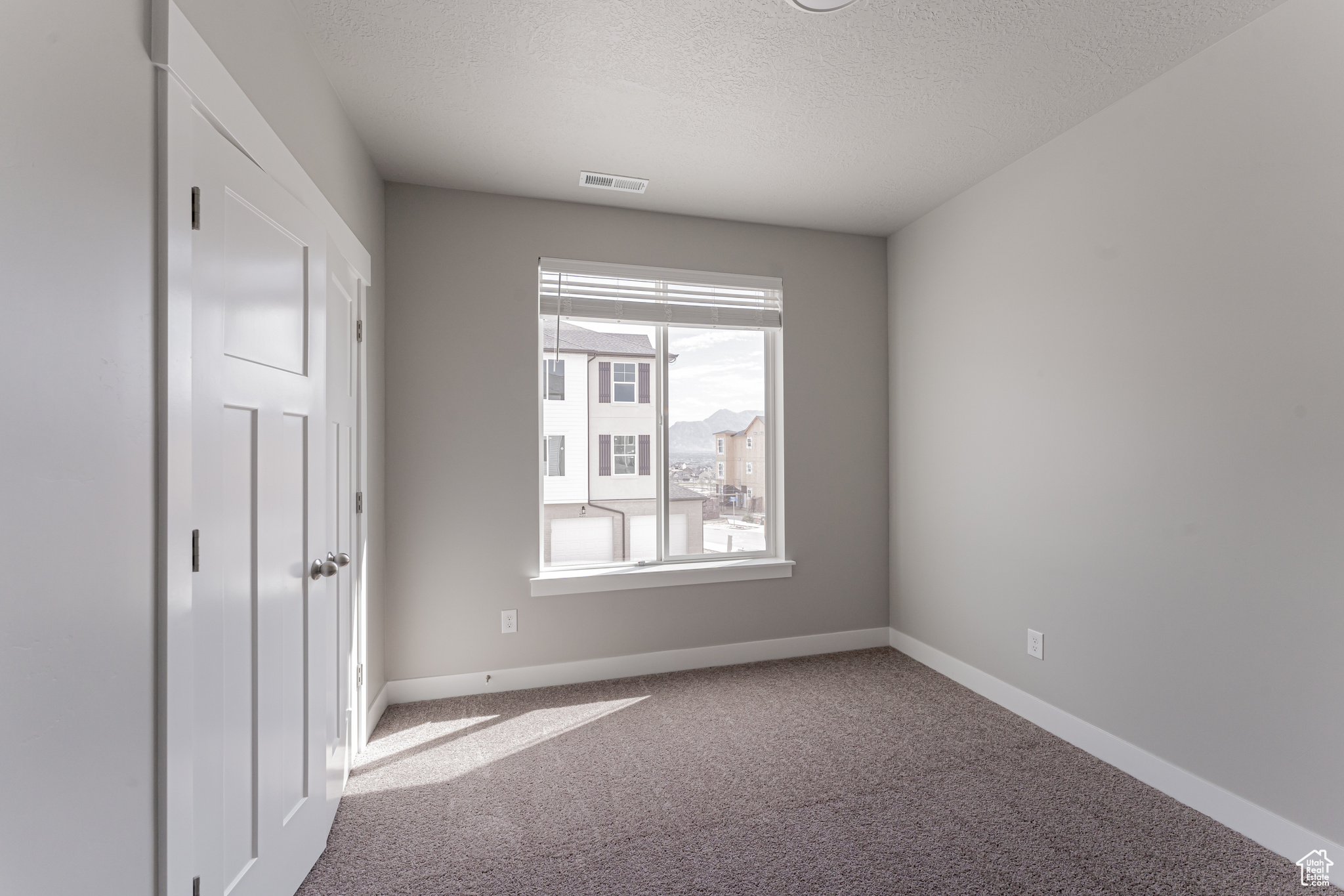 Unfurnished bedroom featuring carpet and a textured ceiling