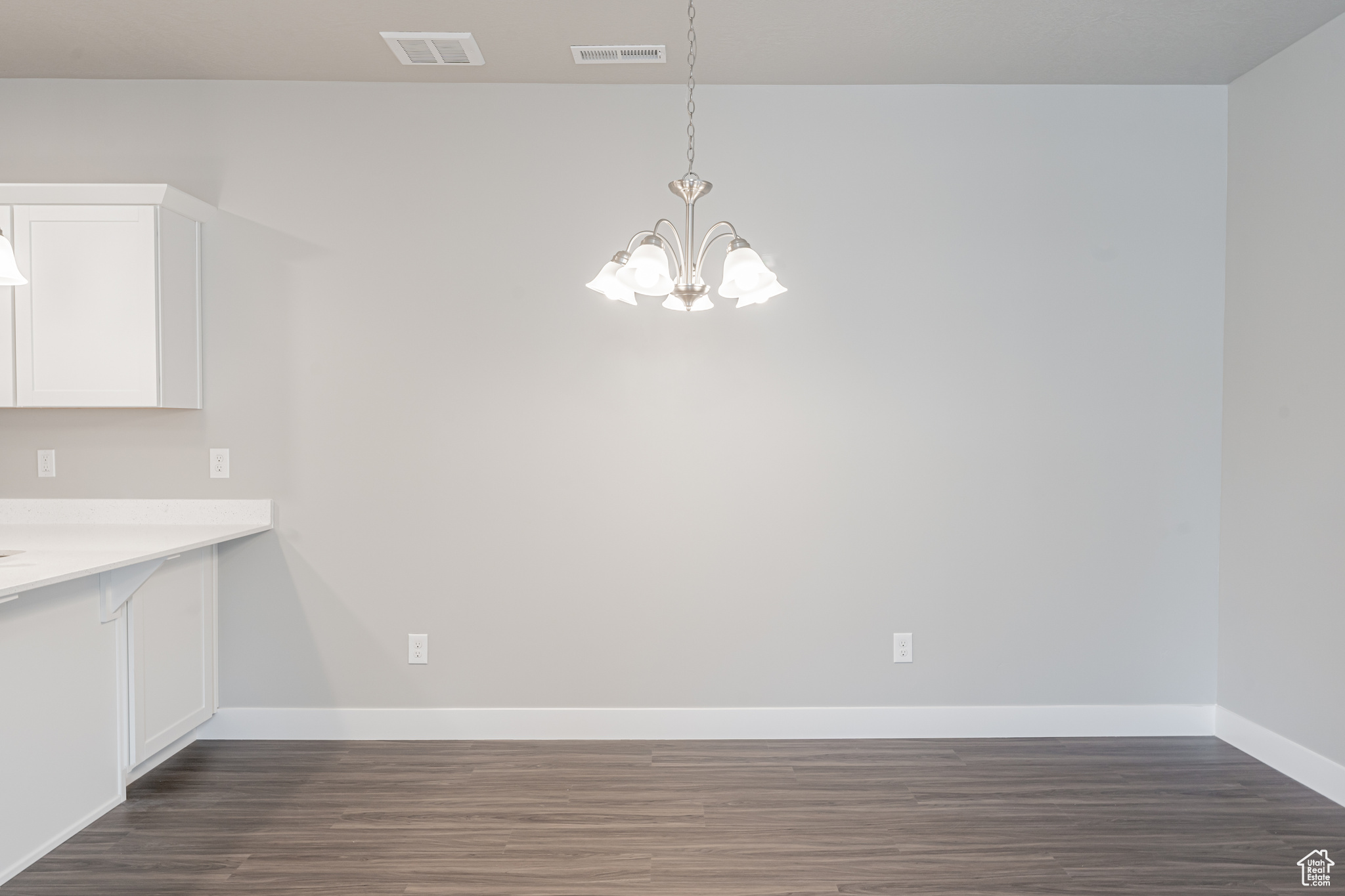 Unfurnished dining area with dark hardwood / wood-style flooring and a chandelier