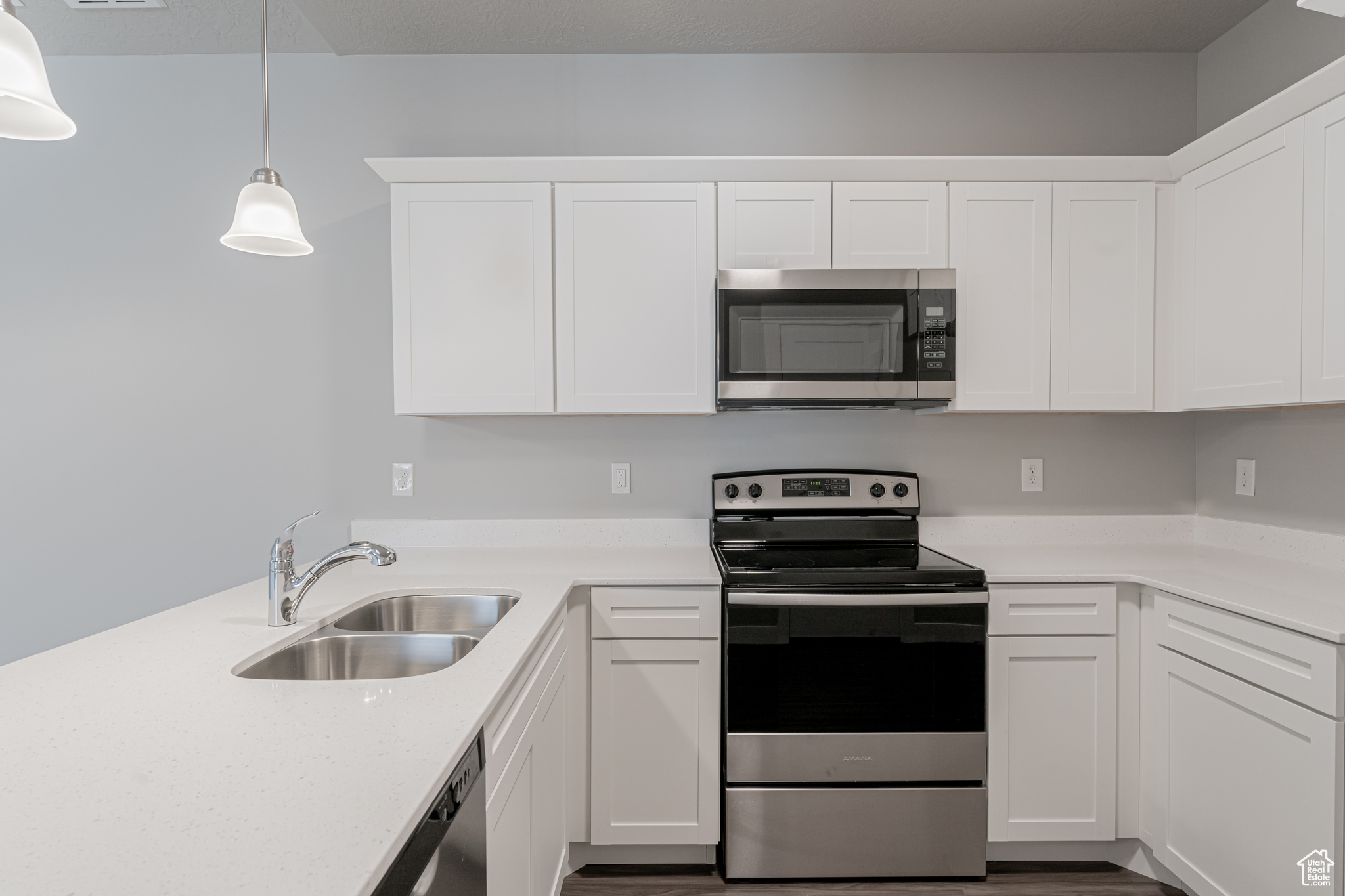 Kitchen featuring sink, stainless steel appliances, and white cabinetry