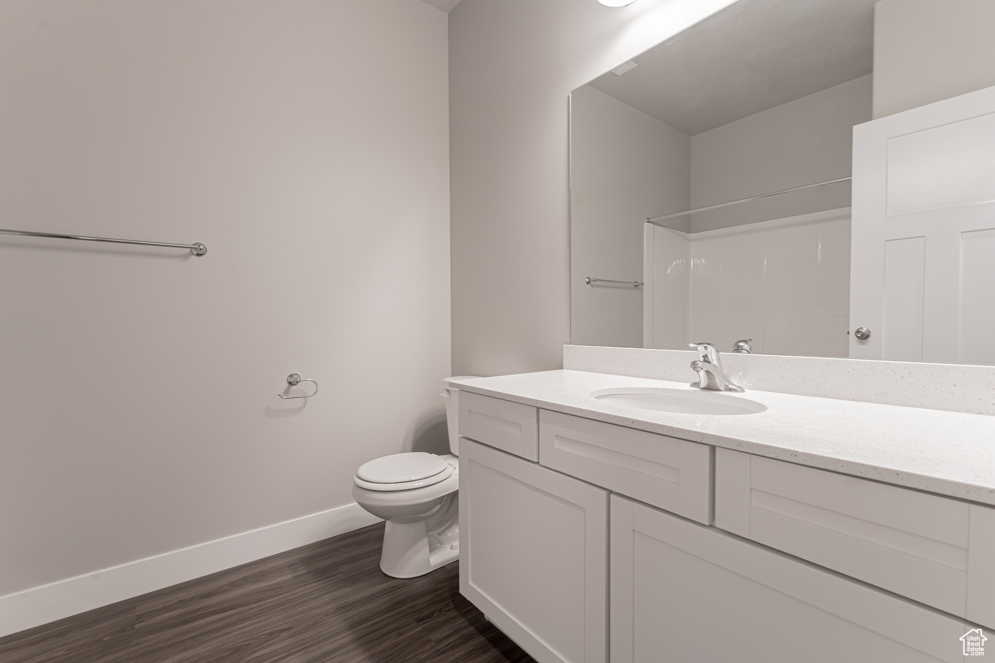 Bathroom featuring toilet, vanity, and wood-type flooring