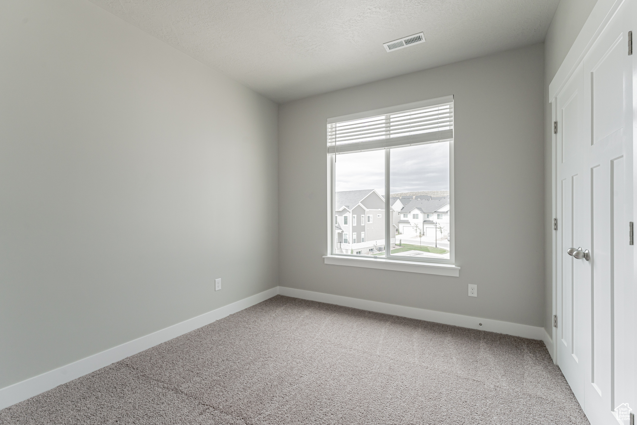 Unfurnished bedroom with light colored carpet