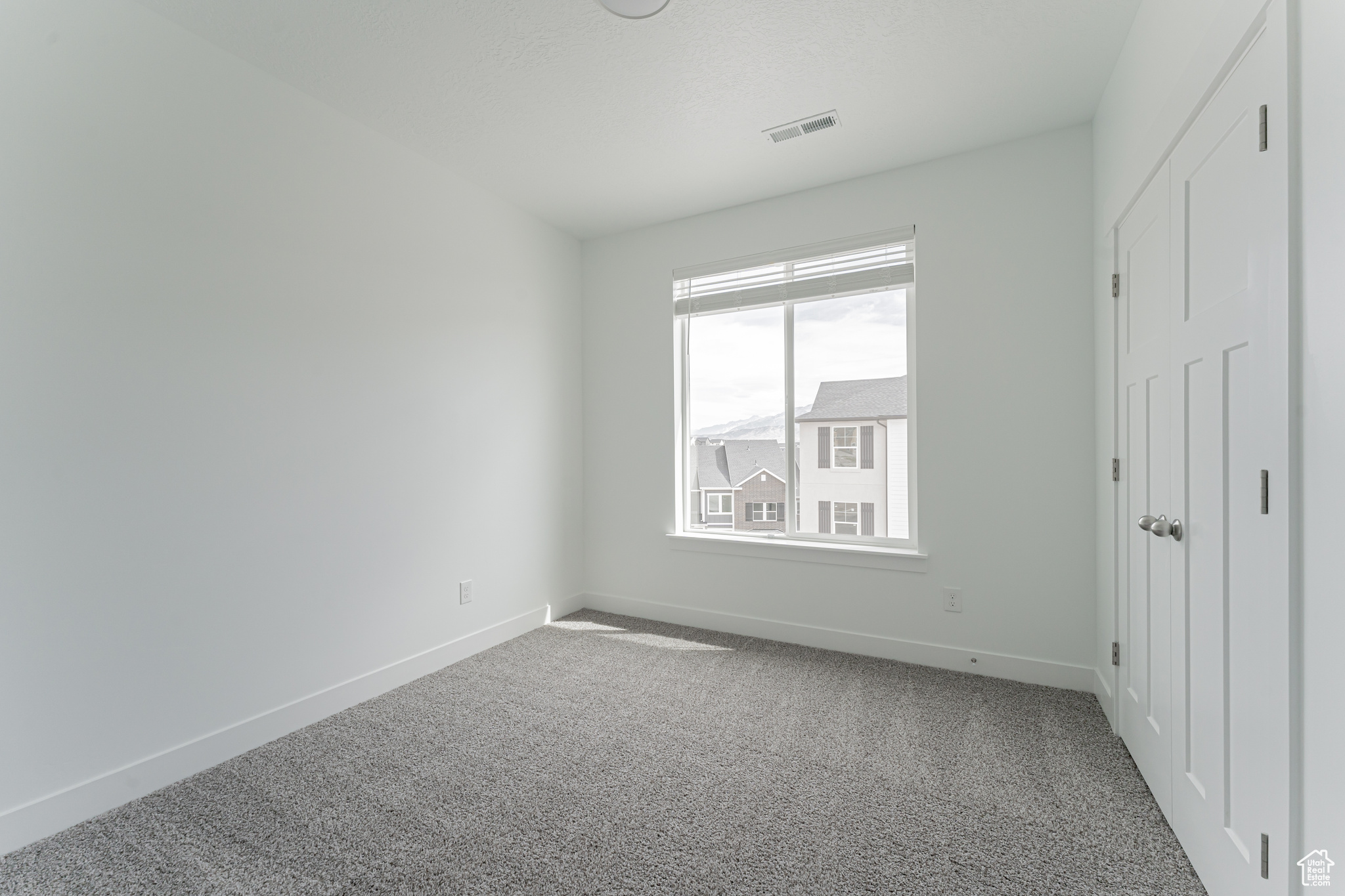 Unfurnished bedroom featuring carpet and multiple windows