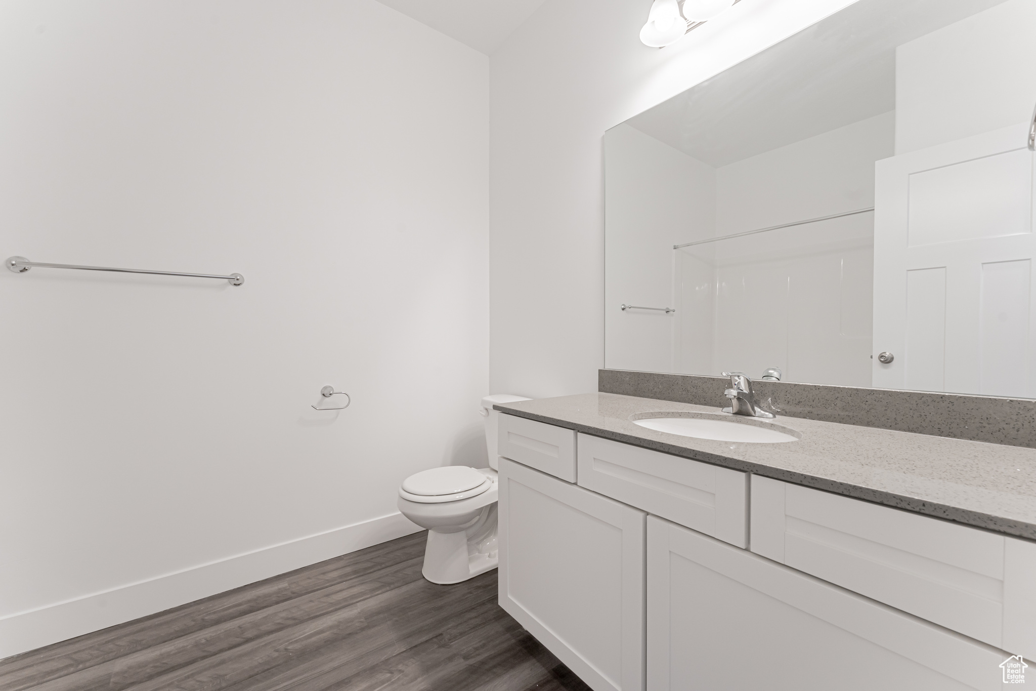 Bathroom featuring hardwood / wood-style floors, toilet, and vanity