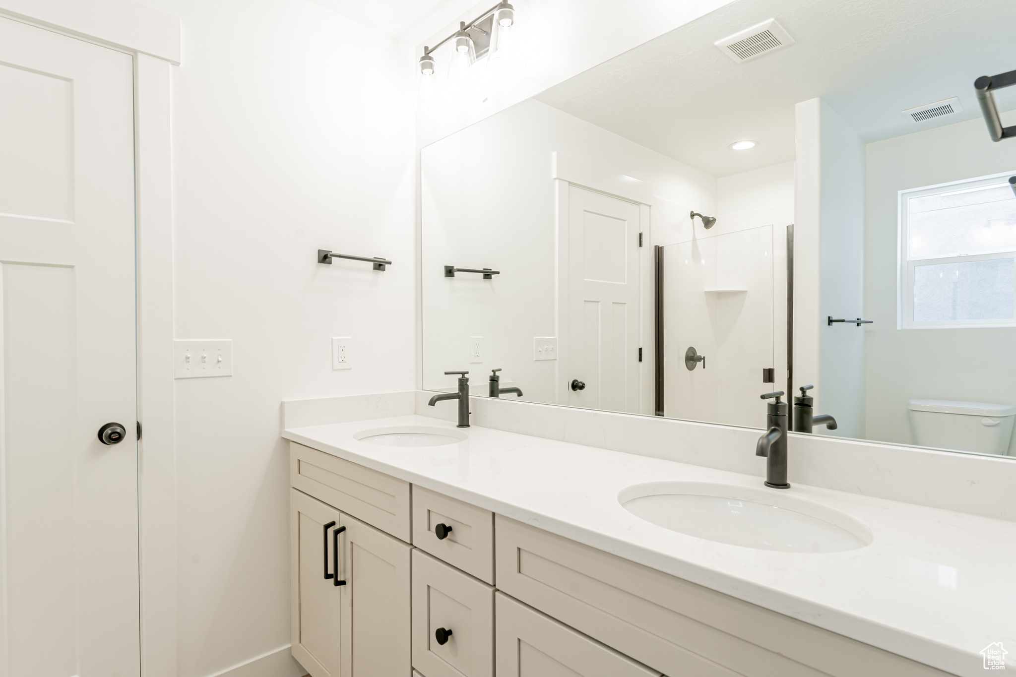 Bathroom with double vanity and toilet