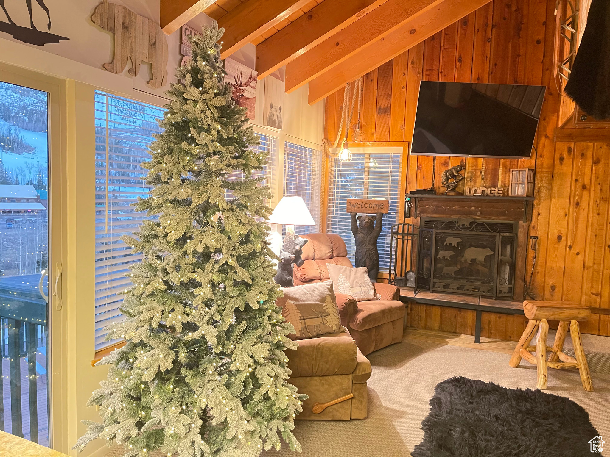 Living room featuring wooden walls, and lofted ceiling with beams