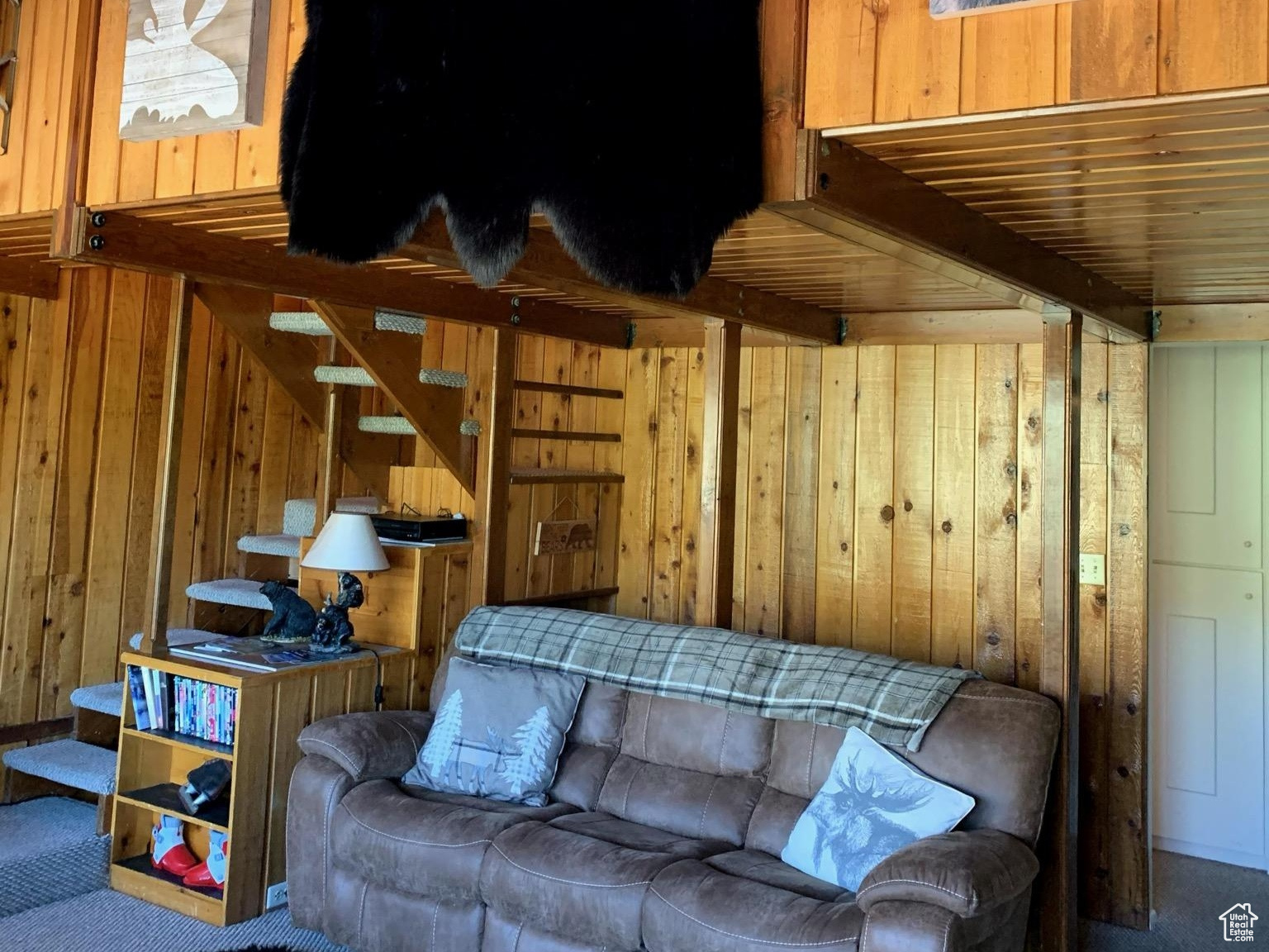 Living room with wooden walls and beamed ceiling