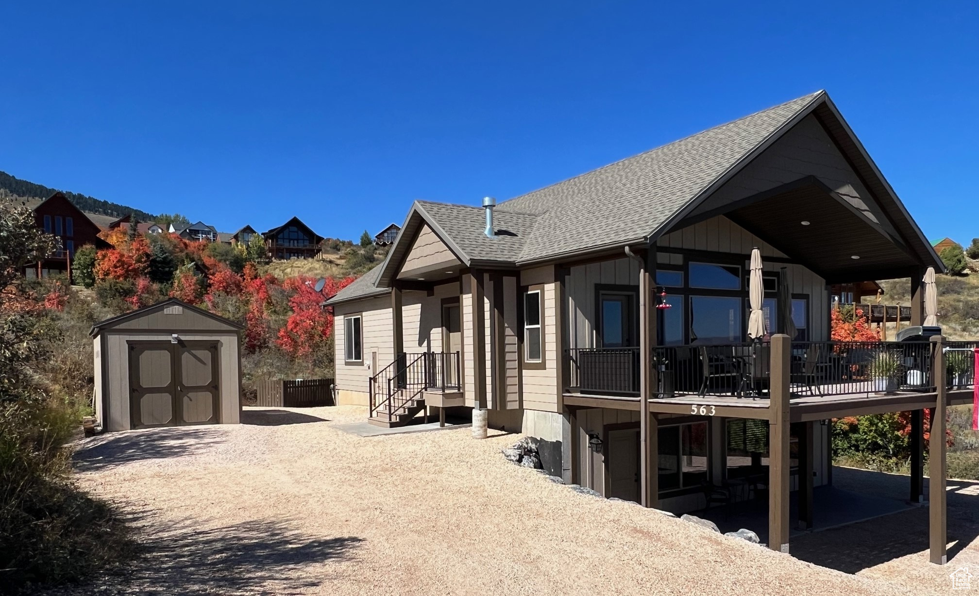 Southeast of house featuring a patio, a deck, and a storage shed