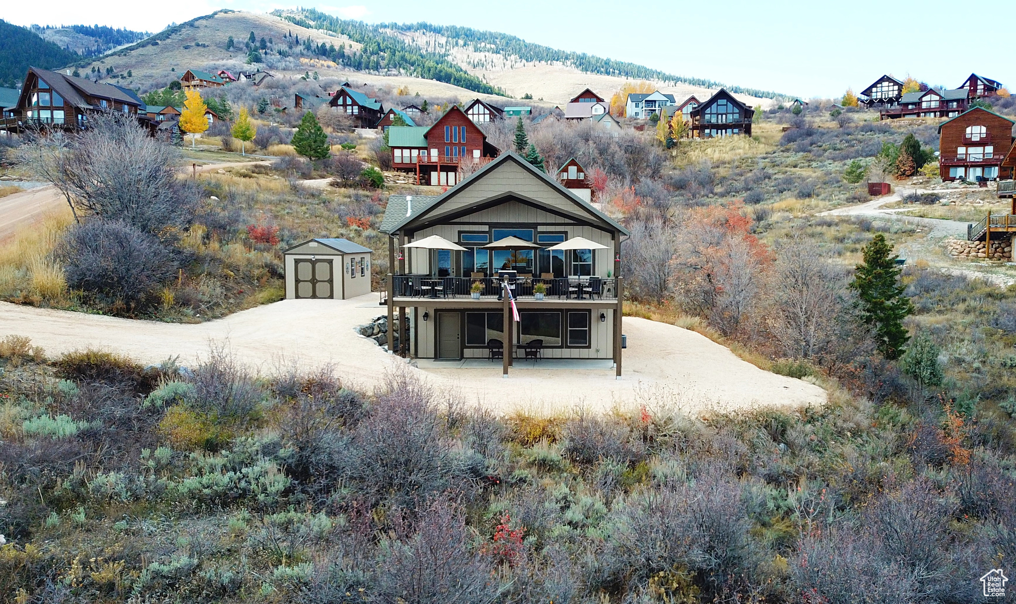 Back of house with a mountain view, an outdoor structure, and a balcony