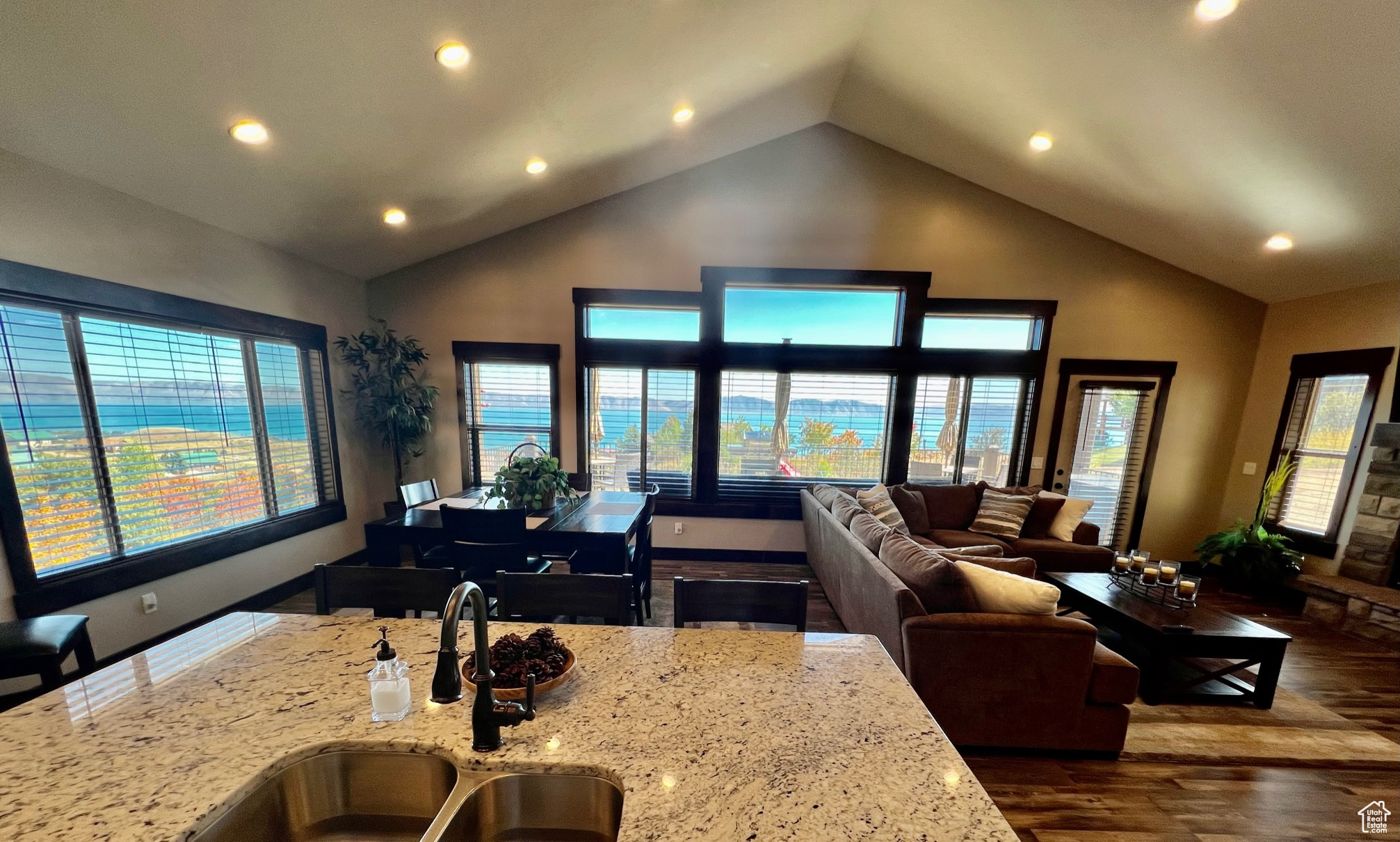 Kitchen featuring dark hardwood / wood-style flooring, sink, granite countertops, and high vaulted ceiling