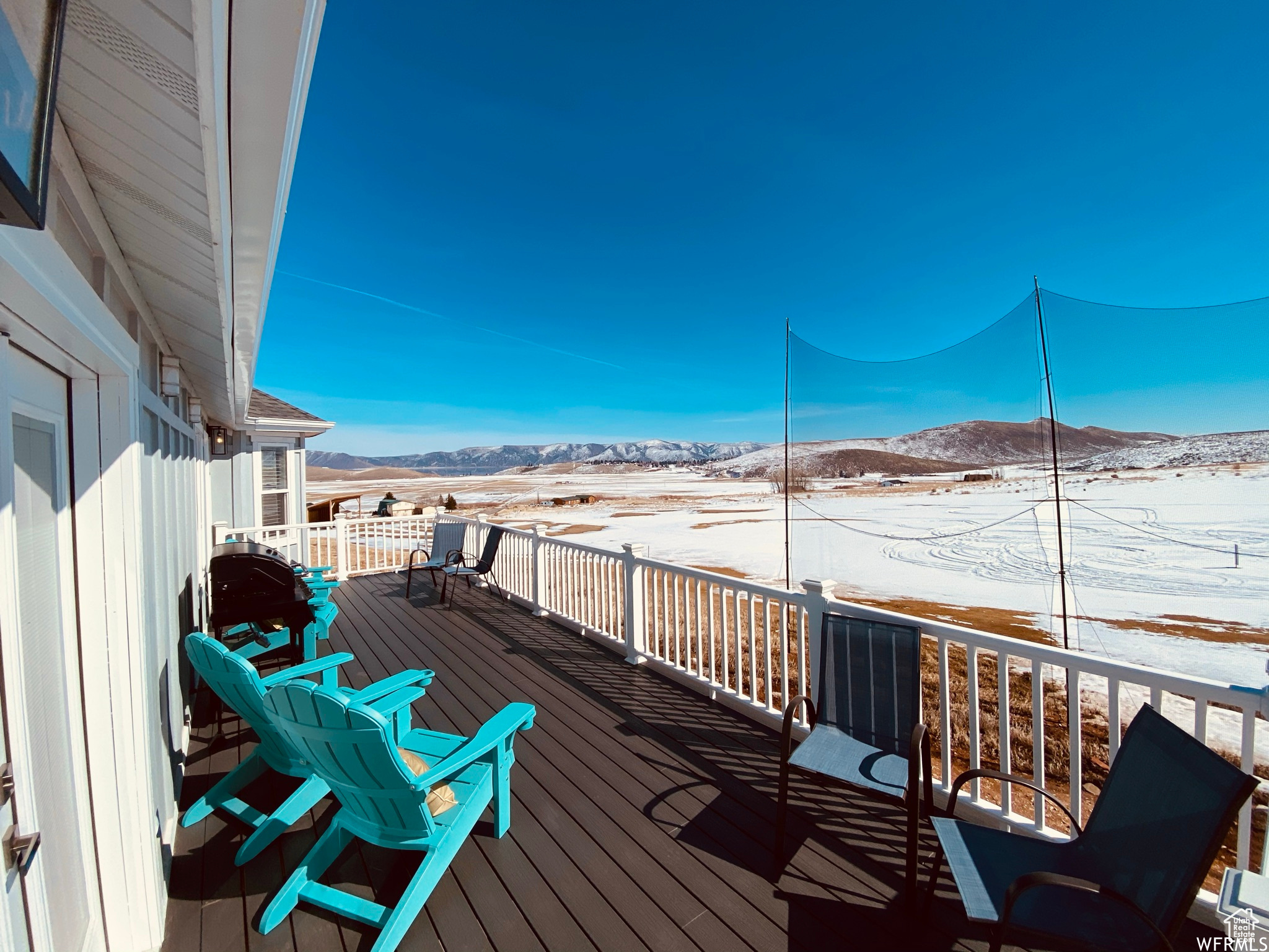 Snow covered deck with a mountain view