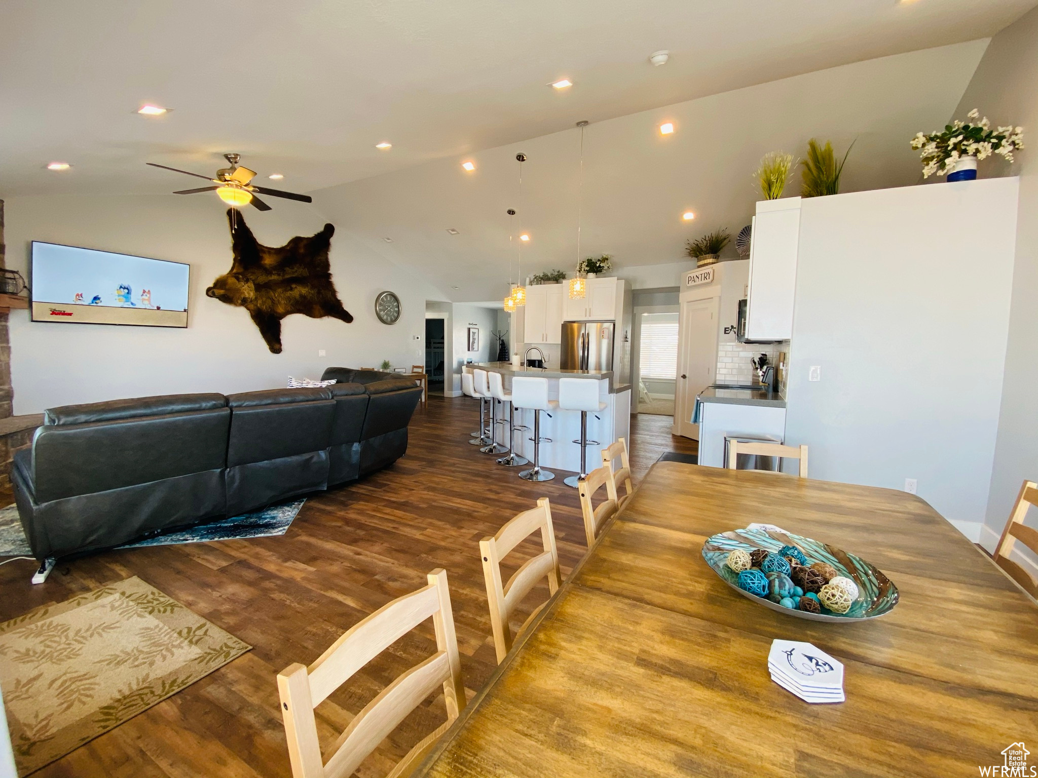 Dining space featuring wood-type flooring, vaulted ceiling, and ceiling fan