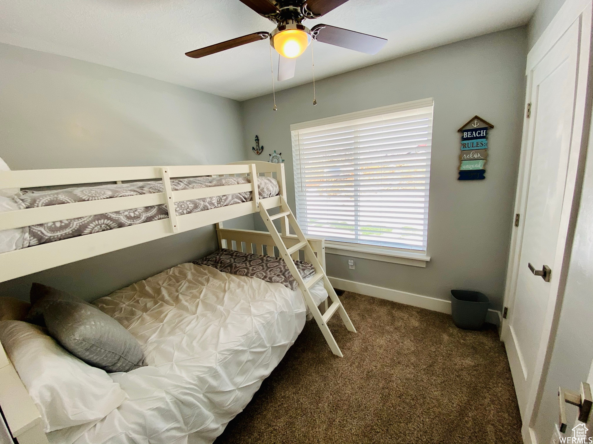 Carpeted bedroom featuring ceiling fan