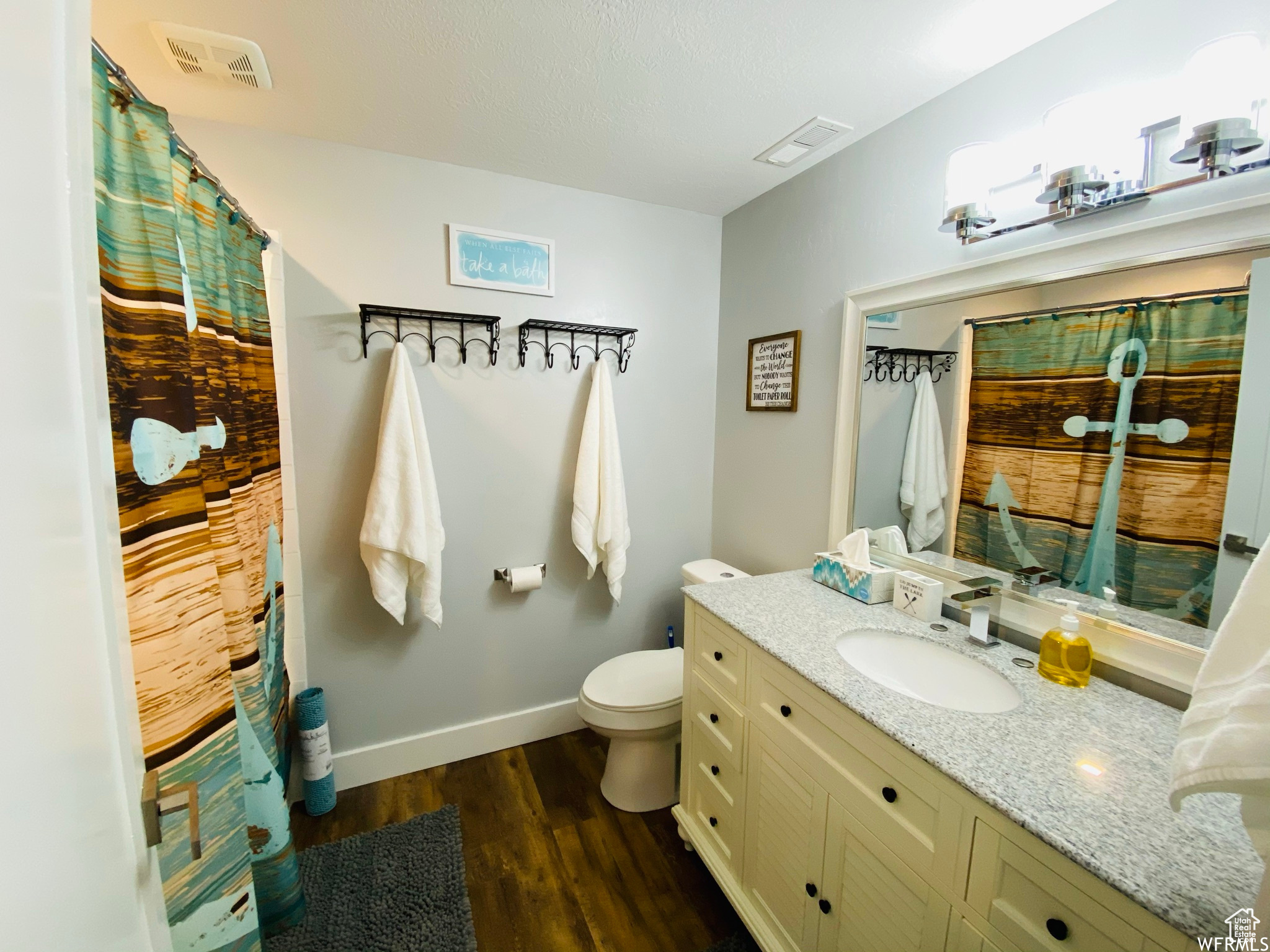 Bathroom featuring vanity, toilet, and hardwood / wood-style floors