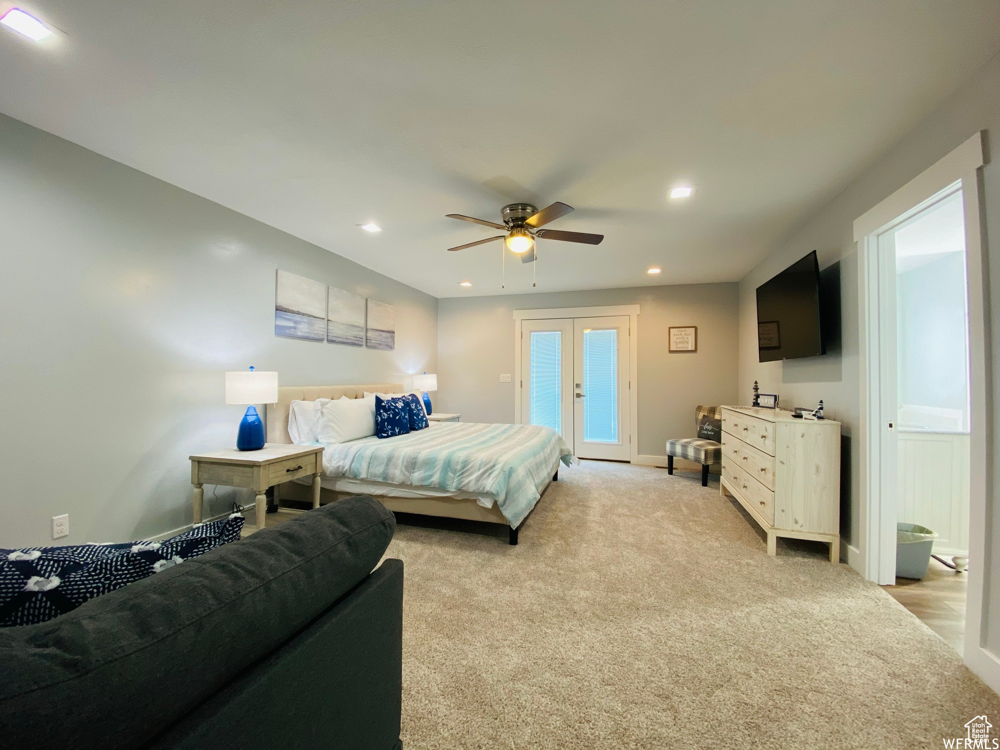 Bedroom with light carpet, french doors, and ceiling fan