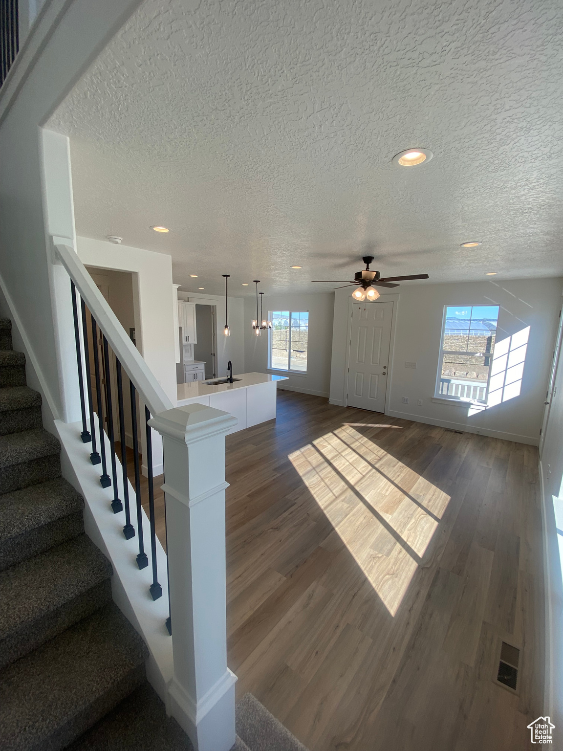 Staircase with sink, hardwood / wood-style flooring, a textured ceiling, and ceiling fan. Pictures are for reference only of the MAINE floor plan. Actual finishes may vary.