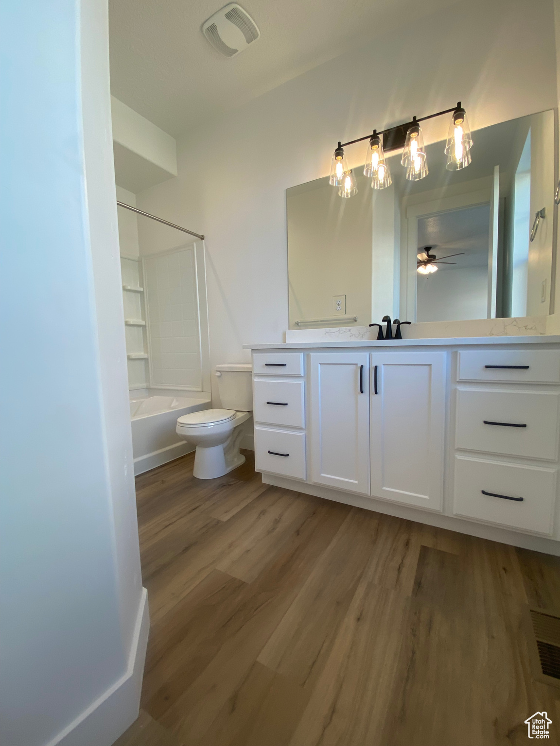 Full bathroom featuring hardwood / wood-style floors, vanity, ceiling fan, toilet, and bathing tub / shower combination. Pictures are for reference only of the MAINE floor plan. Actual finishes may vary.