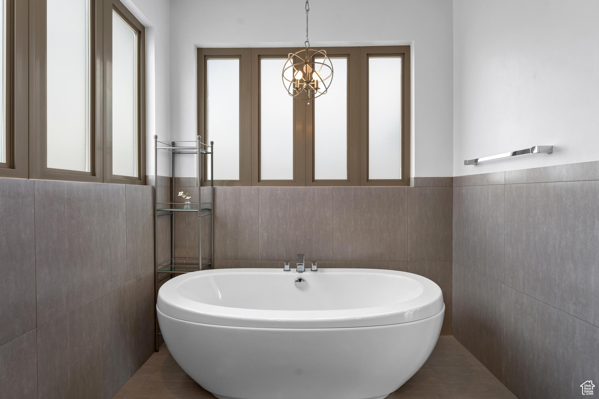 Bathroom with a bath to relax in, tile floors, and tile walls