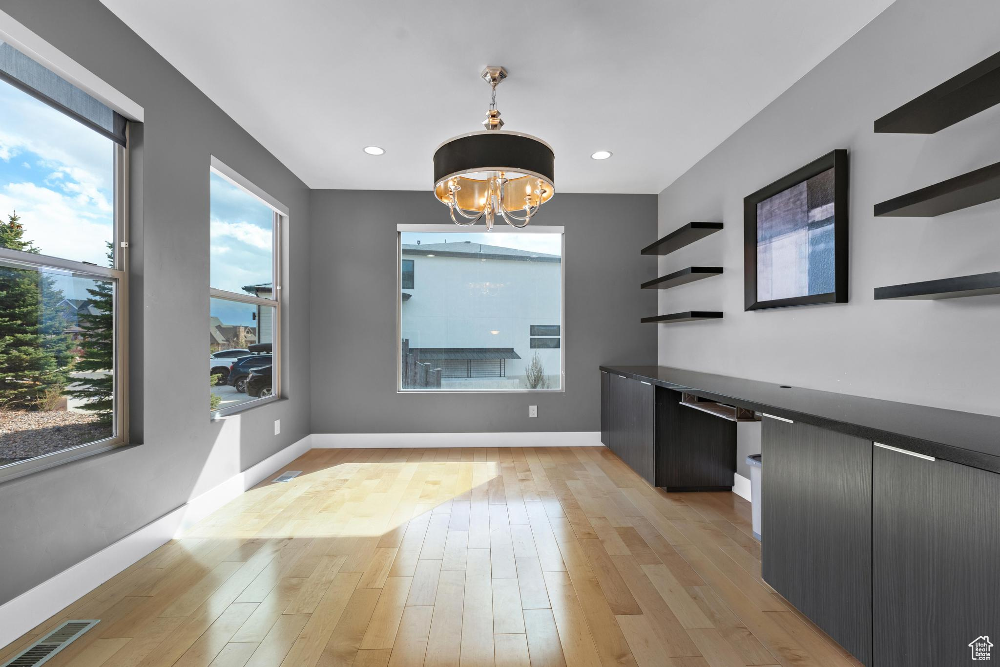 Interior space featuring a notable chandelier, light hardwood / wood-style flooring, and a healthy amount of sunlight