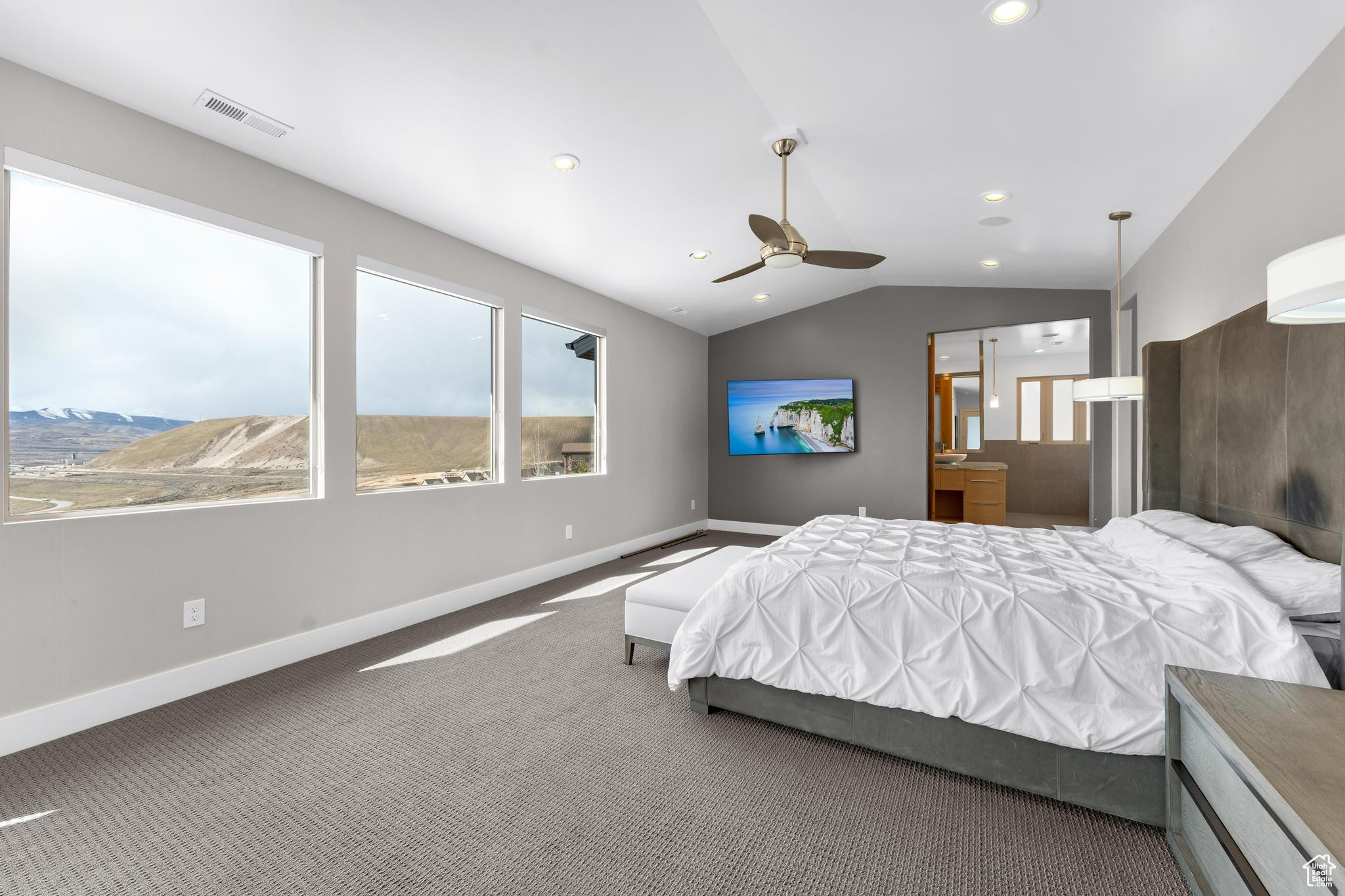 Bedroom with dark carpet, lofted ceiling, and ceiling fan