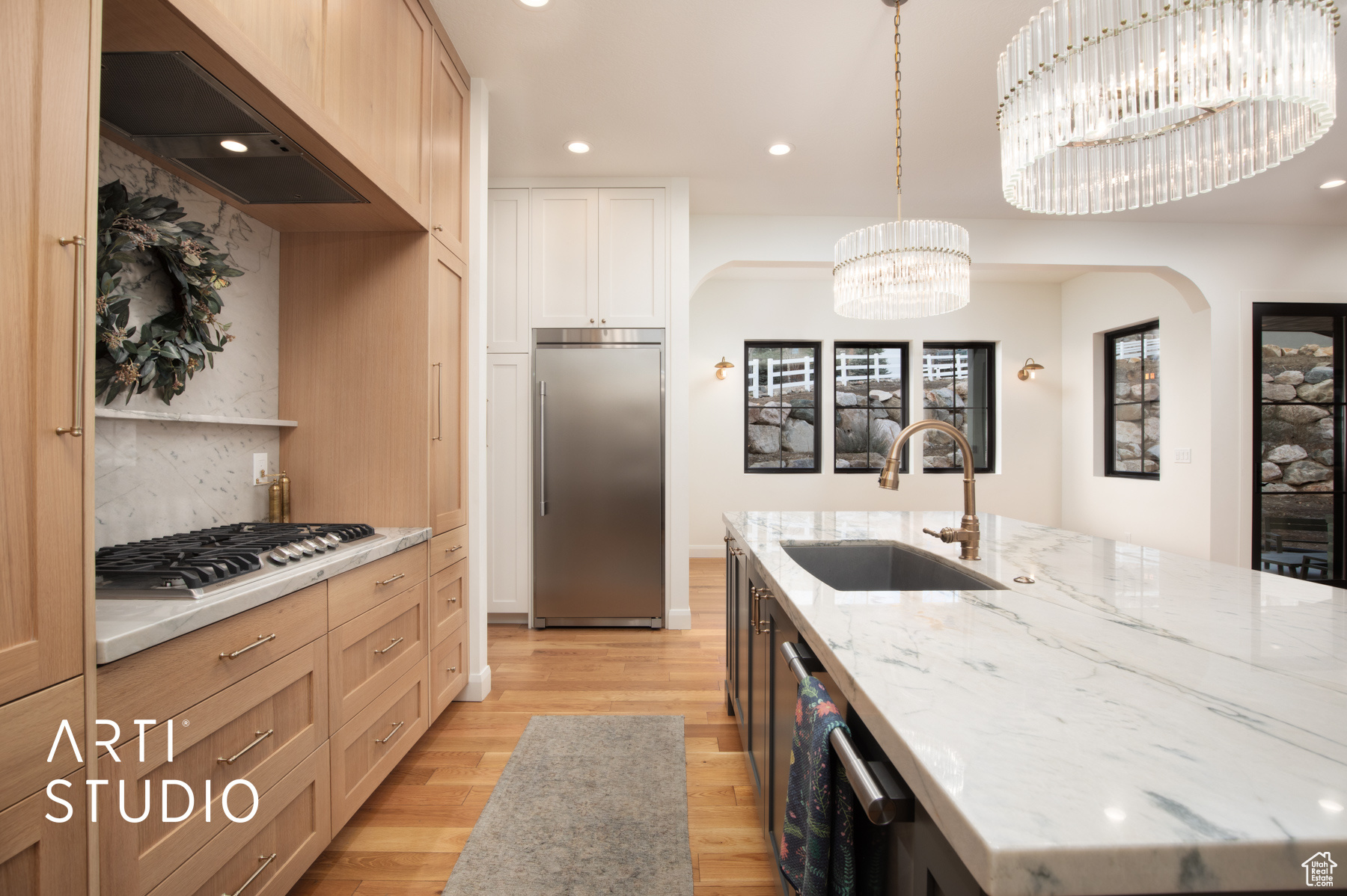 Kitchen featuring light hardwood / wood-style flooring, an inviting chandelier, sink, stainless steel appliances, and custom exhaust hood
