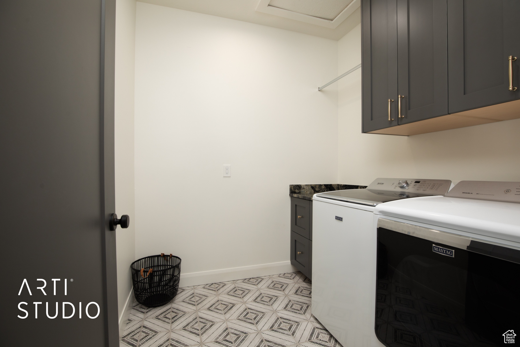 Laundry room with cabinets, light tile floors, and washing machine and dryer