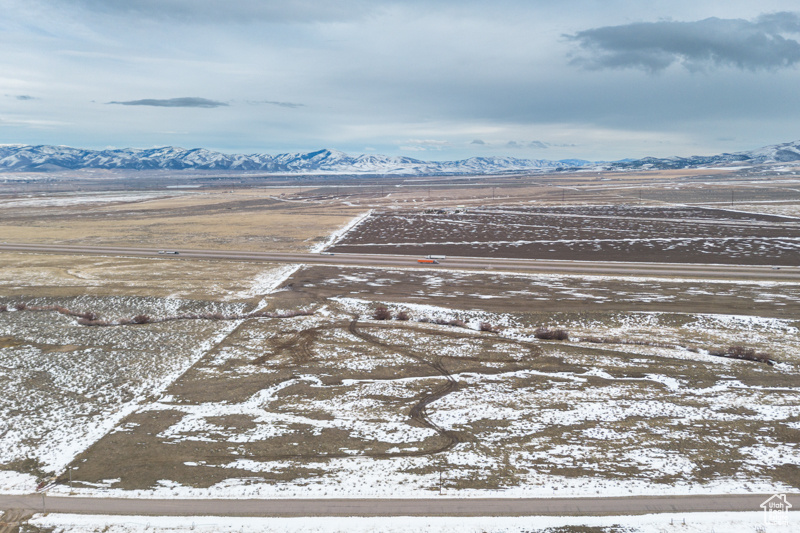 Snowy aerial view with a mountain view and a rural view