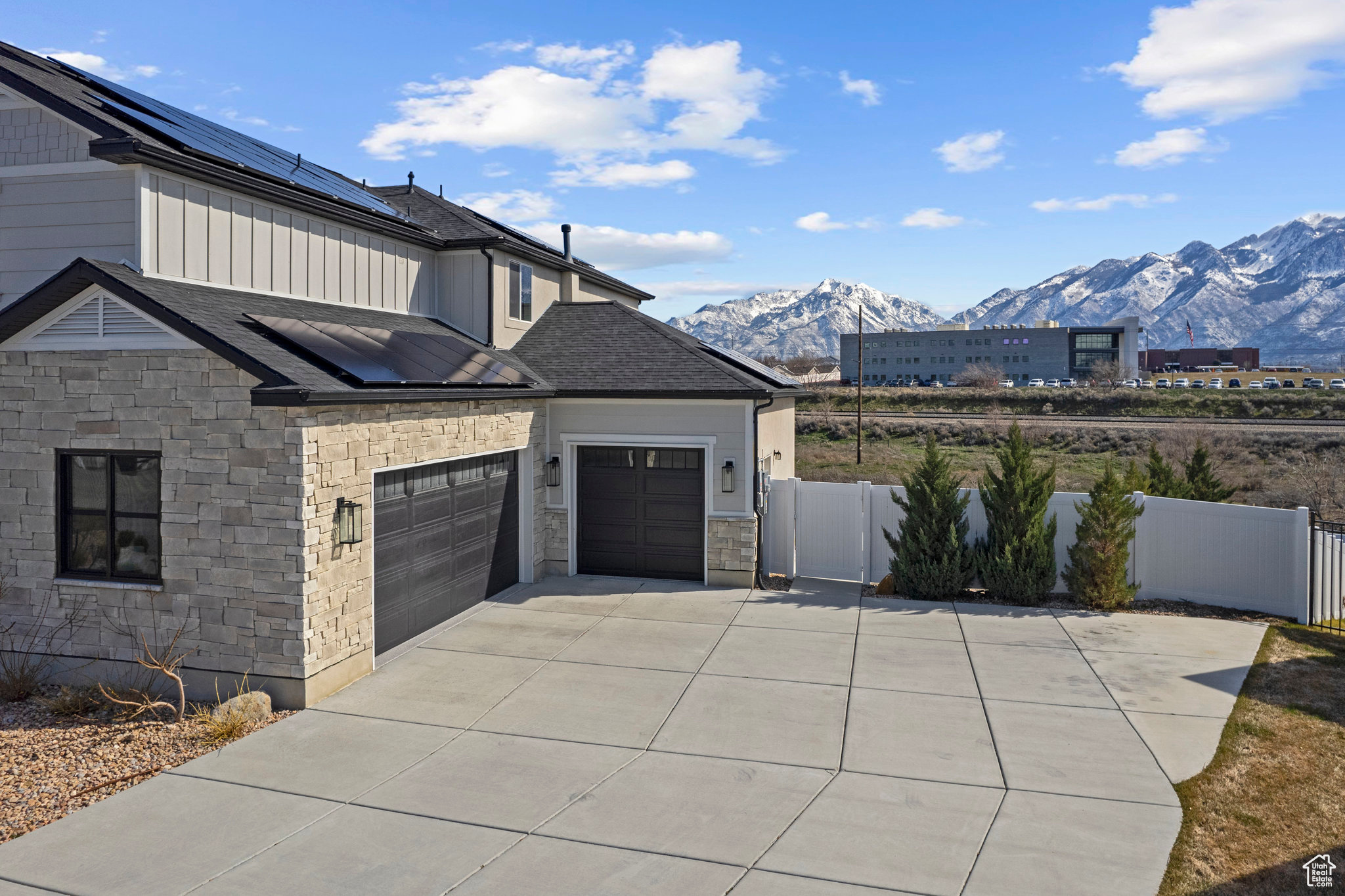 View of home's exterior featuring a mountain view, solar panels, and a garage