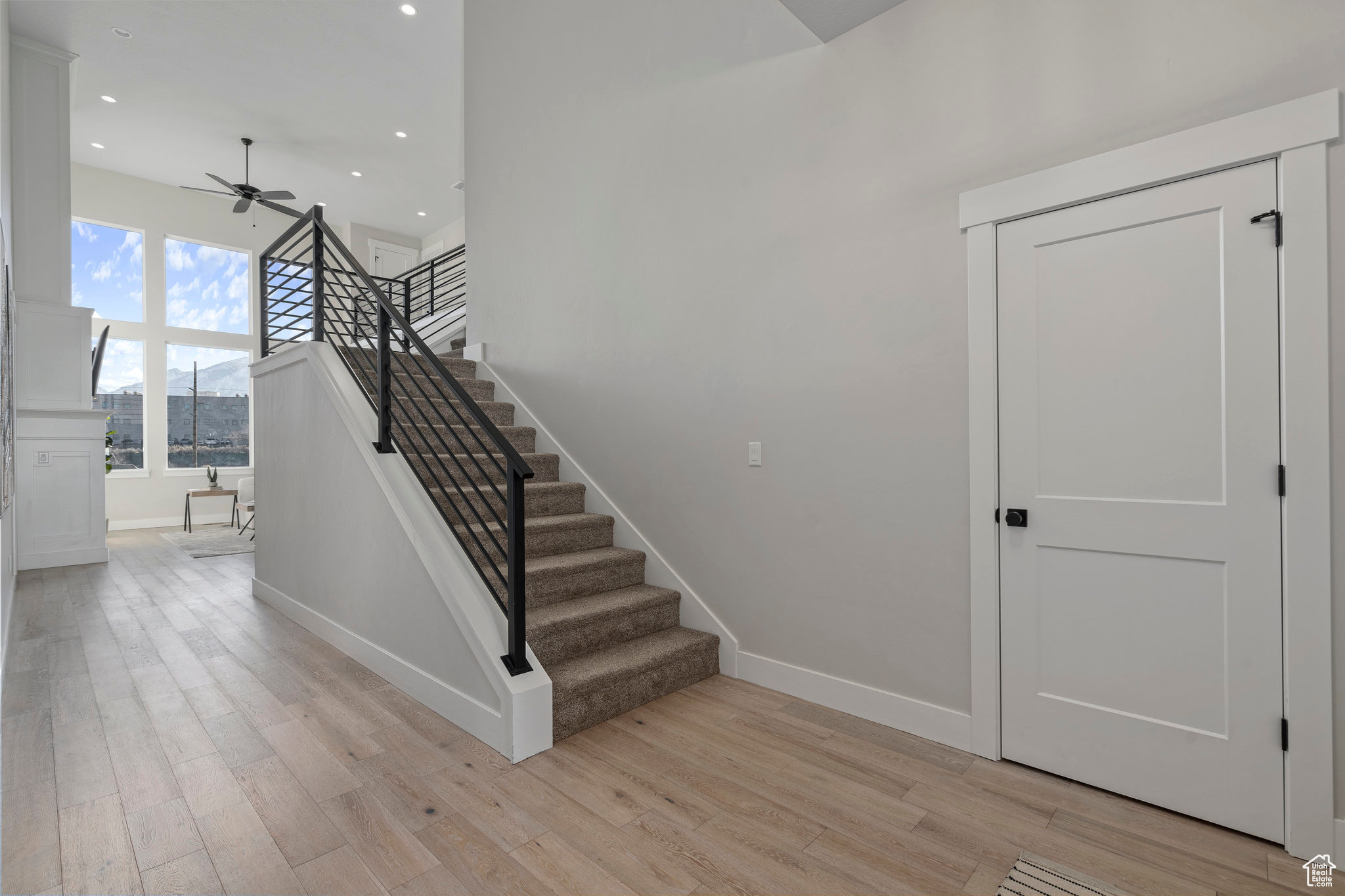 Stairway with ceiling fan and light hardwood / wood-style flooring