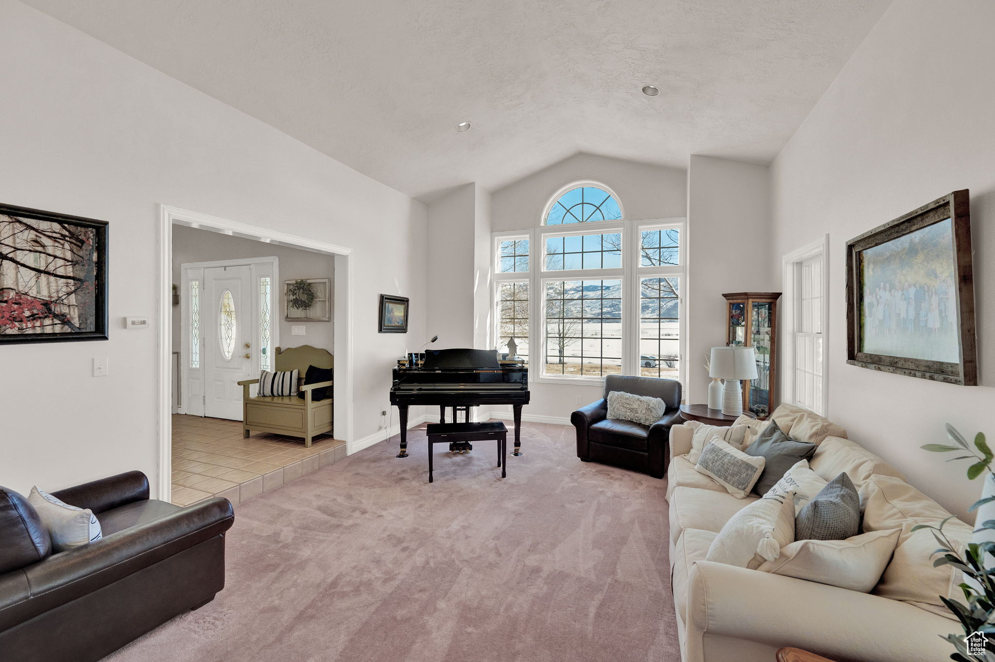 Living room with high vaulted ceiling, a textured ceiling, and tile patterned floors