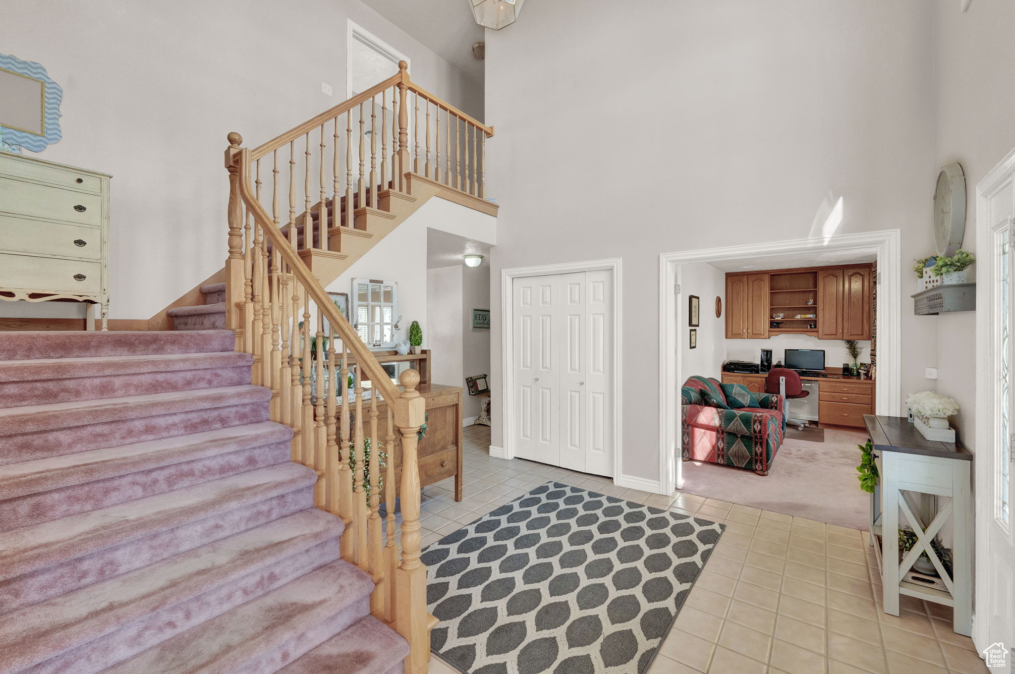 Carpeted entryway with a high ceiling