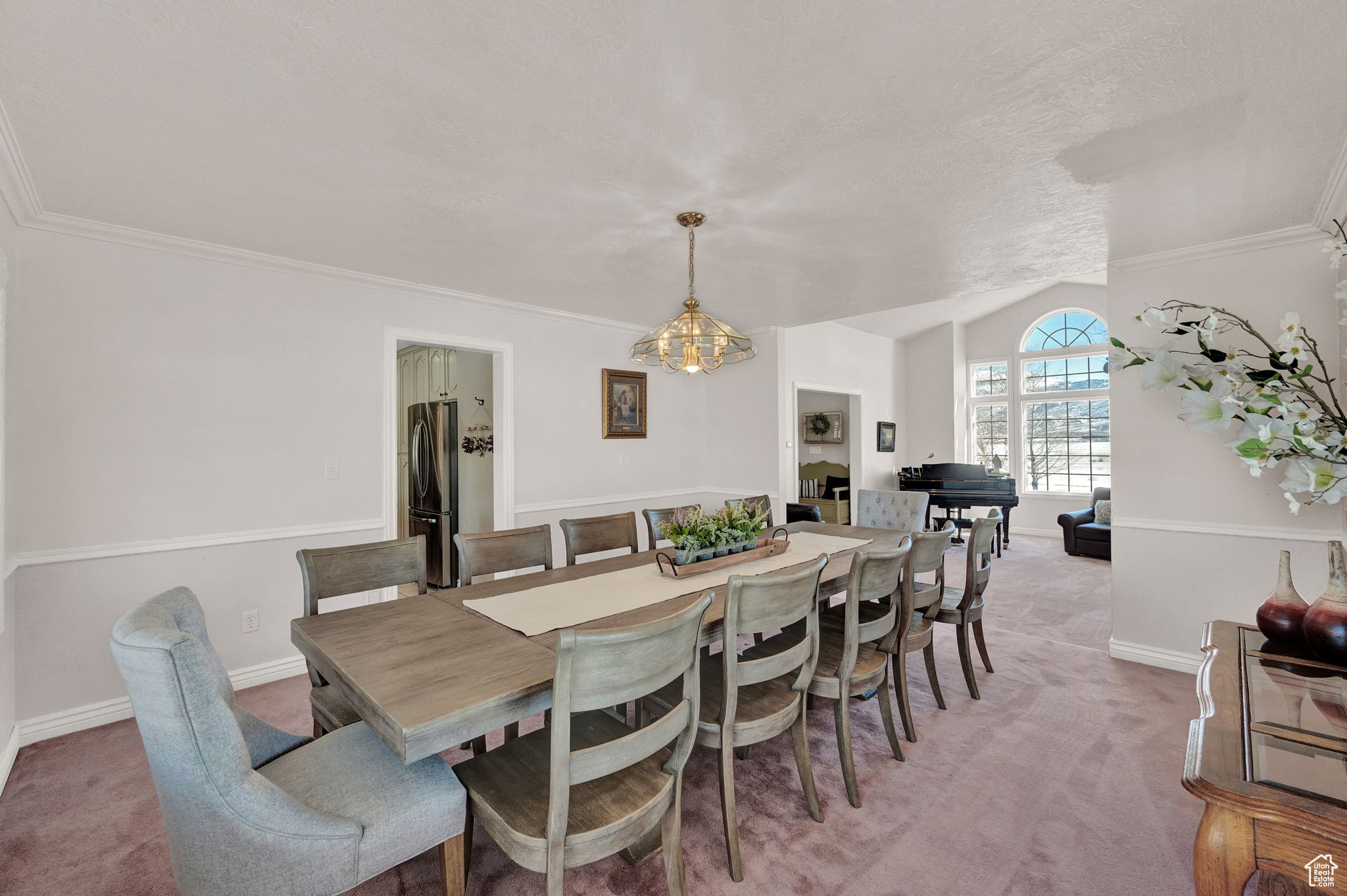 Dining space featuring crown molding, carpet, and a chandelier