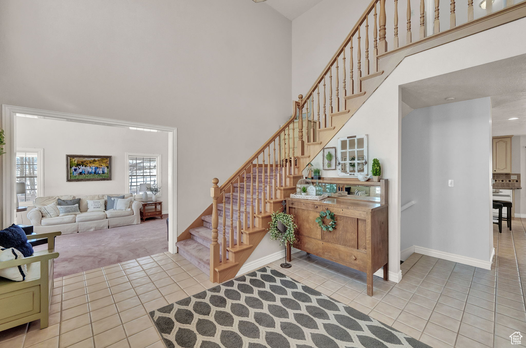 Stairs featuring light carpet and a towering ceiling